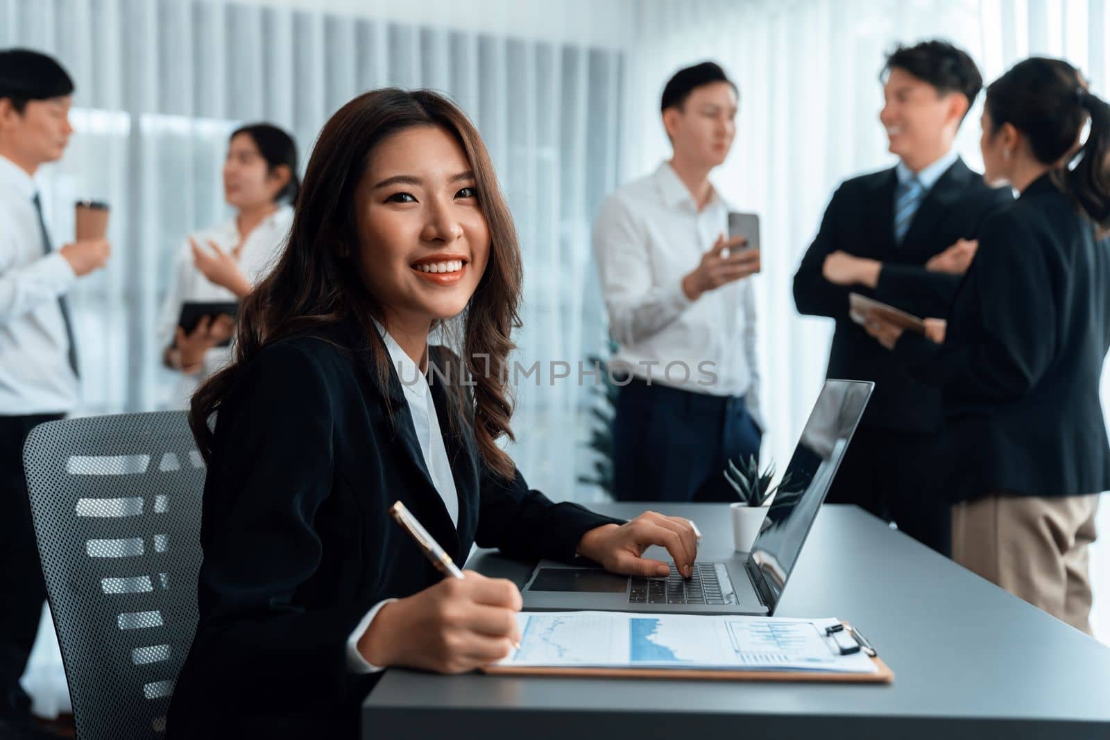 Focus portrait of female manger, businesswoman in the harmony meeting room with blurred of colleagues working together, analyzing financial paper report and dashboard data in background.