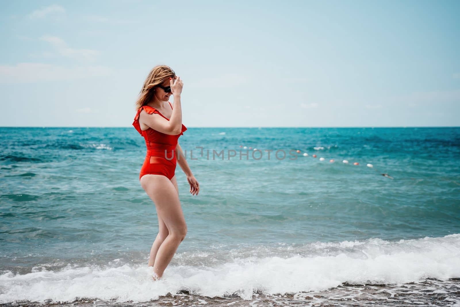 Young happy woman walks carefree on the seaside. Happy lady in red bikini. Portrait beautiful young woman relax smile around beach sea ocean in holiday vacation travel trip by panophotograph