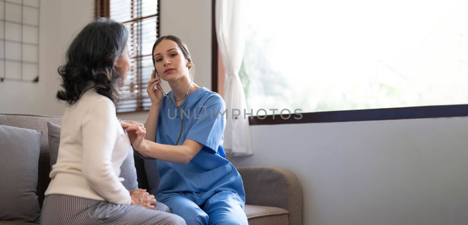 Asian nurse showing health checkup report to grandmather and giving advice. medical assisted living visit senior patient at home. Home nursing and healthcare caregiver concept by wichayada