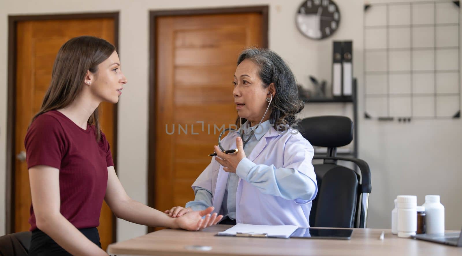 Serious doctor visiting female patient, giving consultation, recommendations, listening to complaints. woman complaining on healthcare problems to physician in white coat..