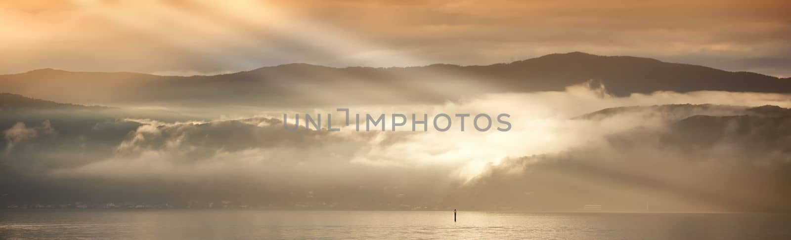 A photo of Sunset, ocean and mountains.