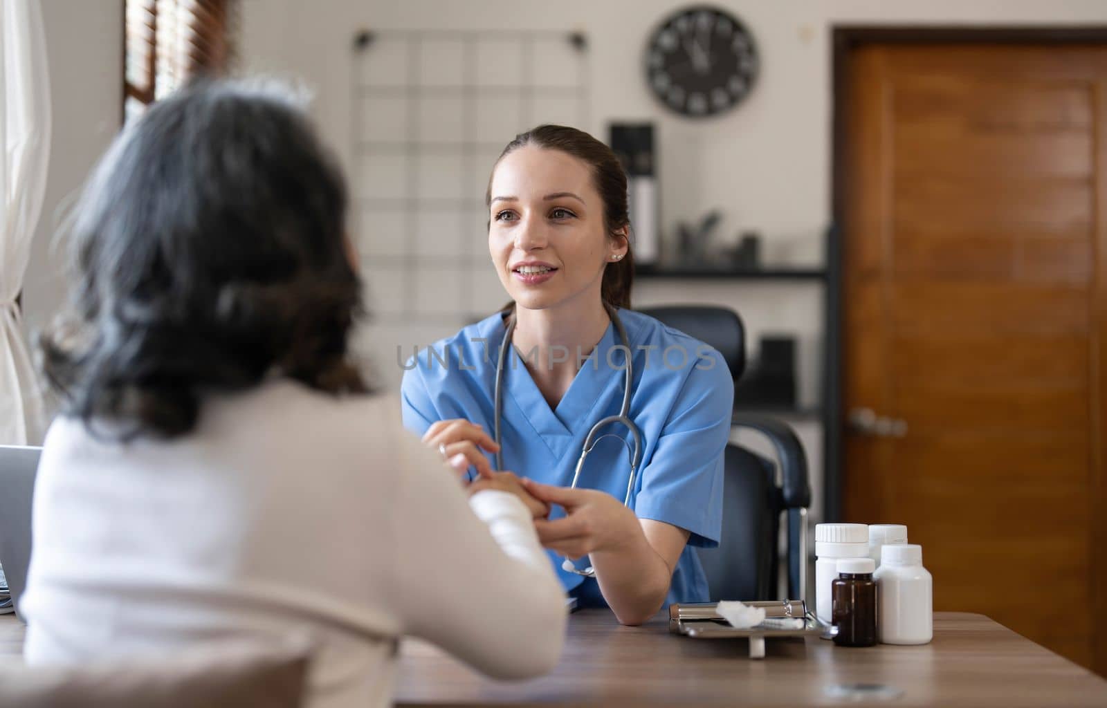 Asian Female Doctor examining and taking note on checklist paper with female patients in medical room...