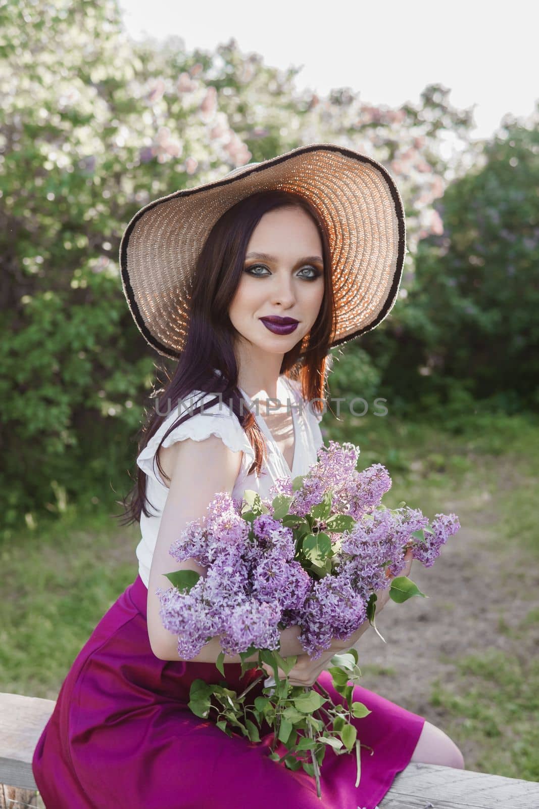 A fashionable girl with dark hair, a spring portrait in lilac tones in summer. Bright professional makeup