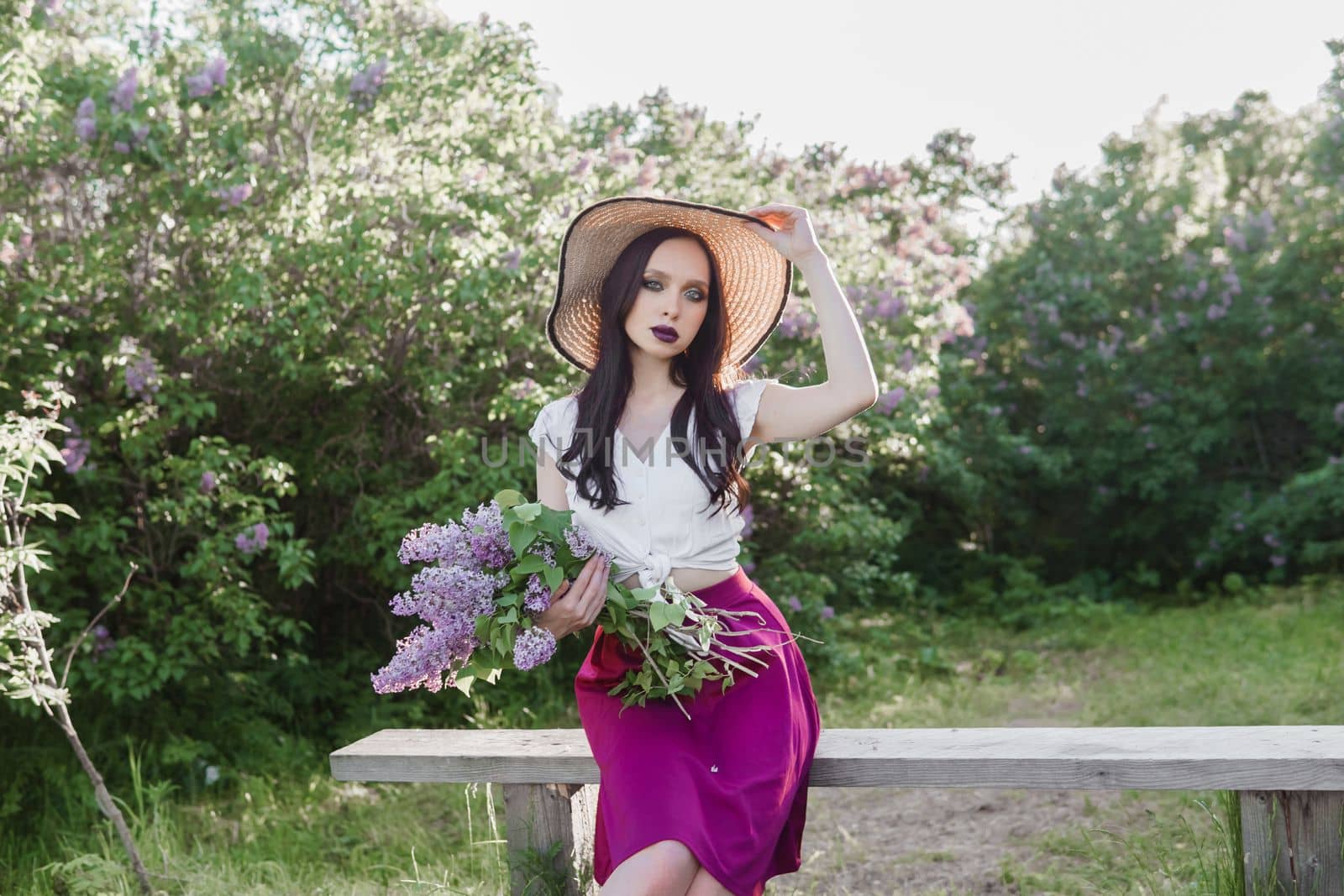 A fashionable girl with dark hair, a spring portrait in lilac tones in summer. Bright professional makeup