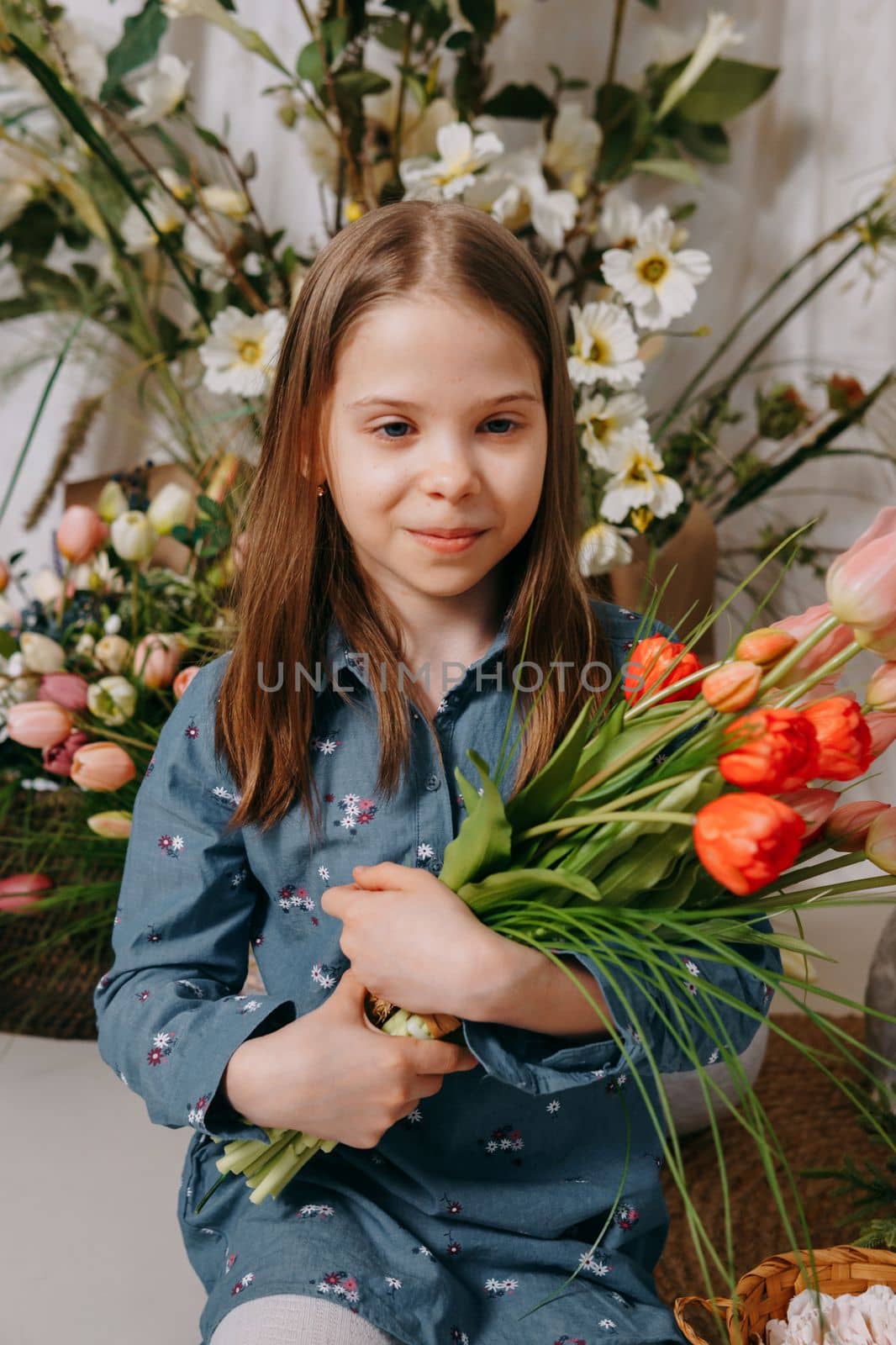 Two girls in a beautiful Easter photo zone with flowers, eggs, chickens and Easter bunnies. Happy Easter holiday