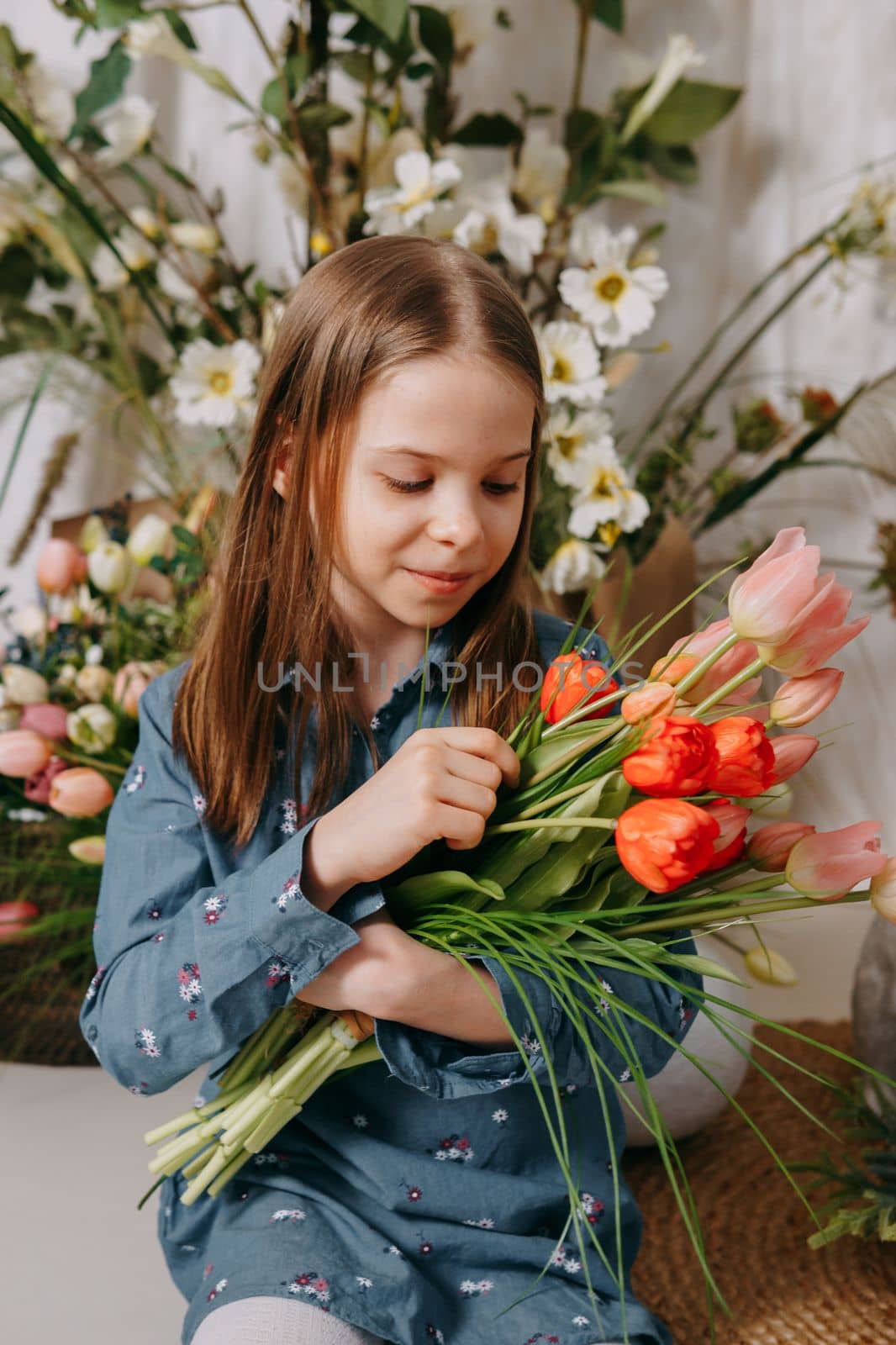 Two girls in a beautiful Easter photo zone with flowers, eggs, chickens and Easter bunnies. Happy Easter holiday