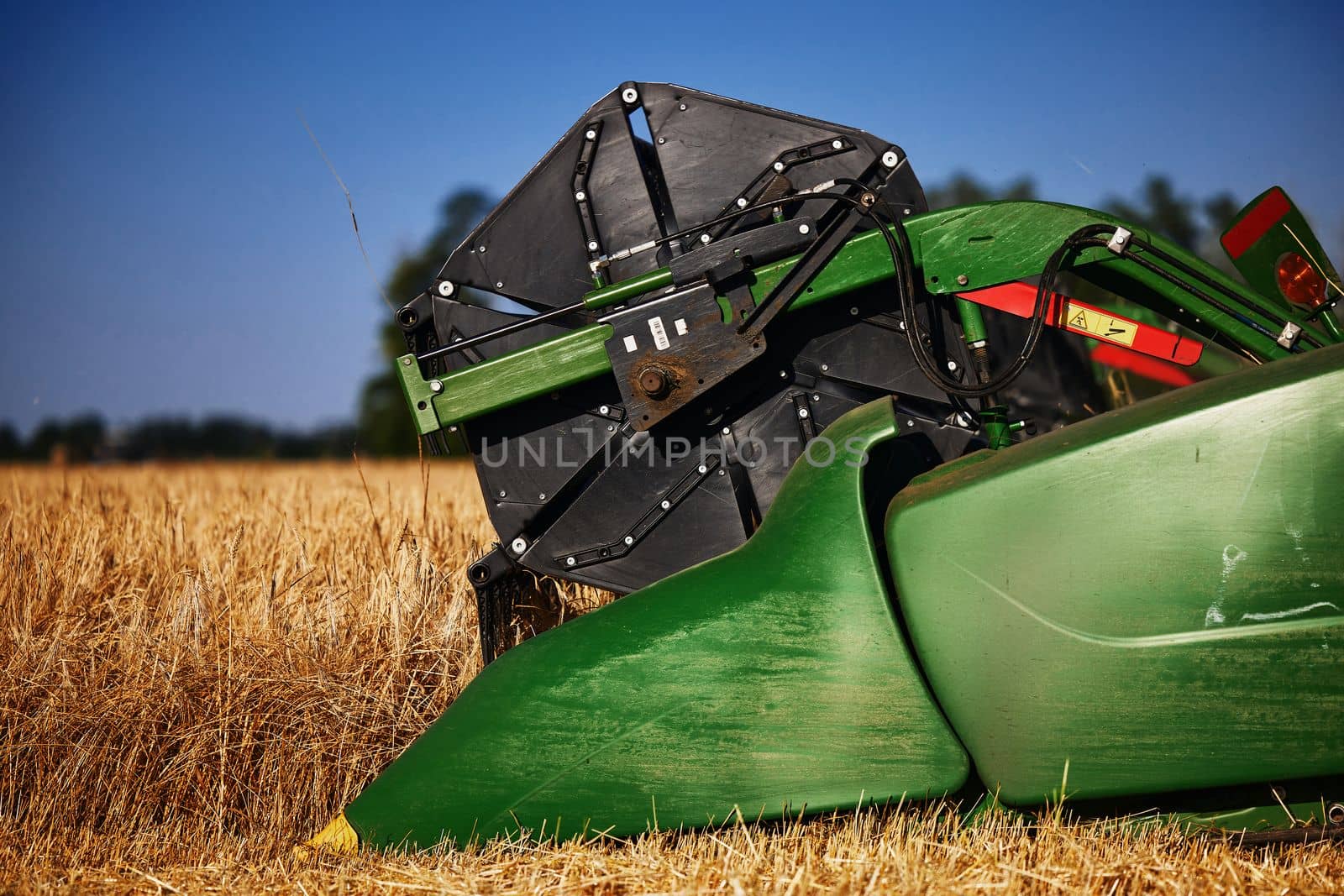 John Deere harvester works in the field. Combine Harvesting Wheat. Field field of cereals during harvesting. Modern equipment works. 07.07.22, Rostov region, Russia.