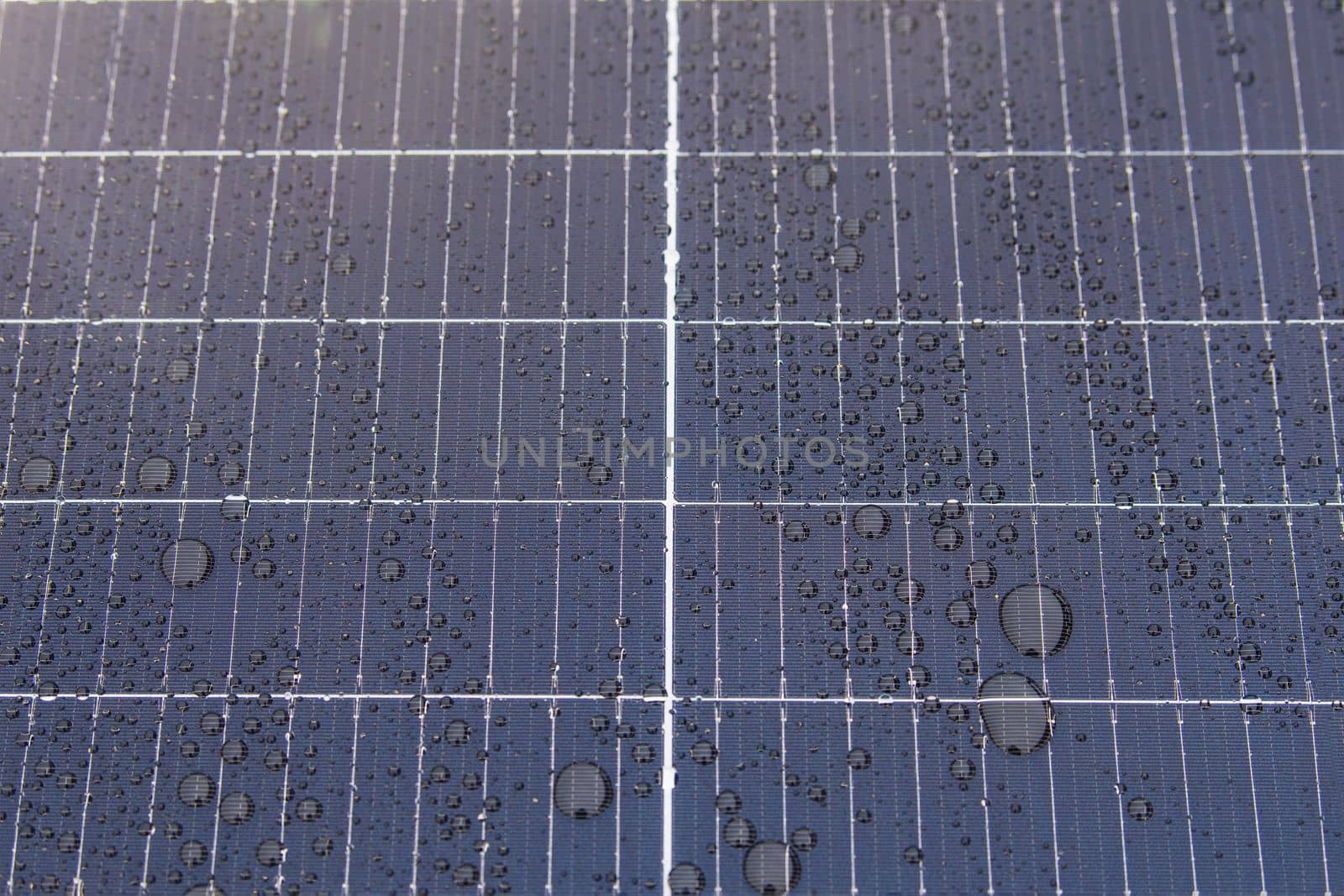 Green energy. Solar panels with raindrops close up. The use of waterproof solar panels in difficult environments, the production of green energy