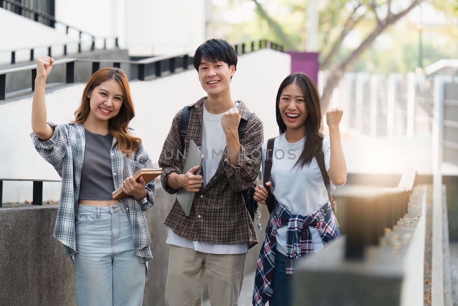 Beautiful young Asian woman college student with friends at outdoors. College student working on the college campus.