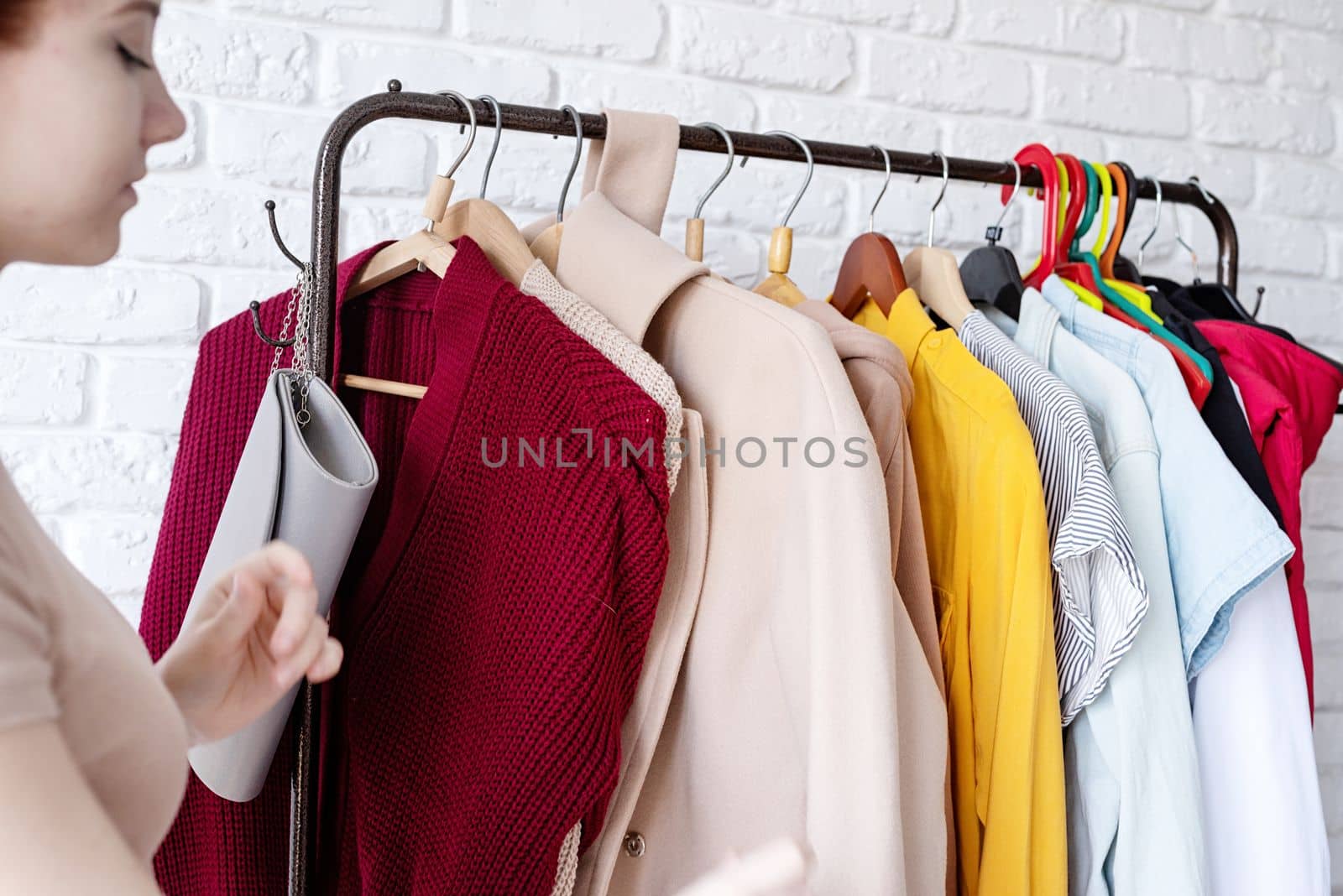 young beautiful woman wearing trendy outfit, standing near clothes rack. Wardrobe change by Desperada