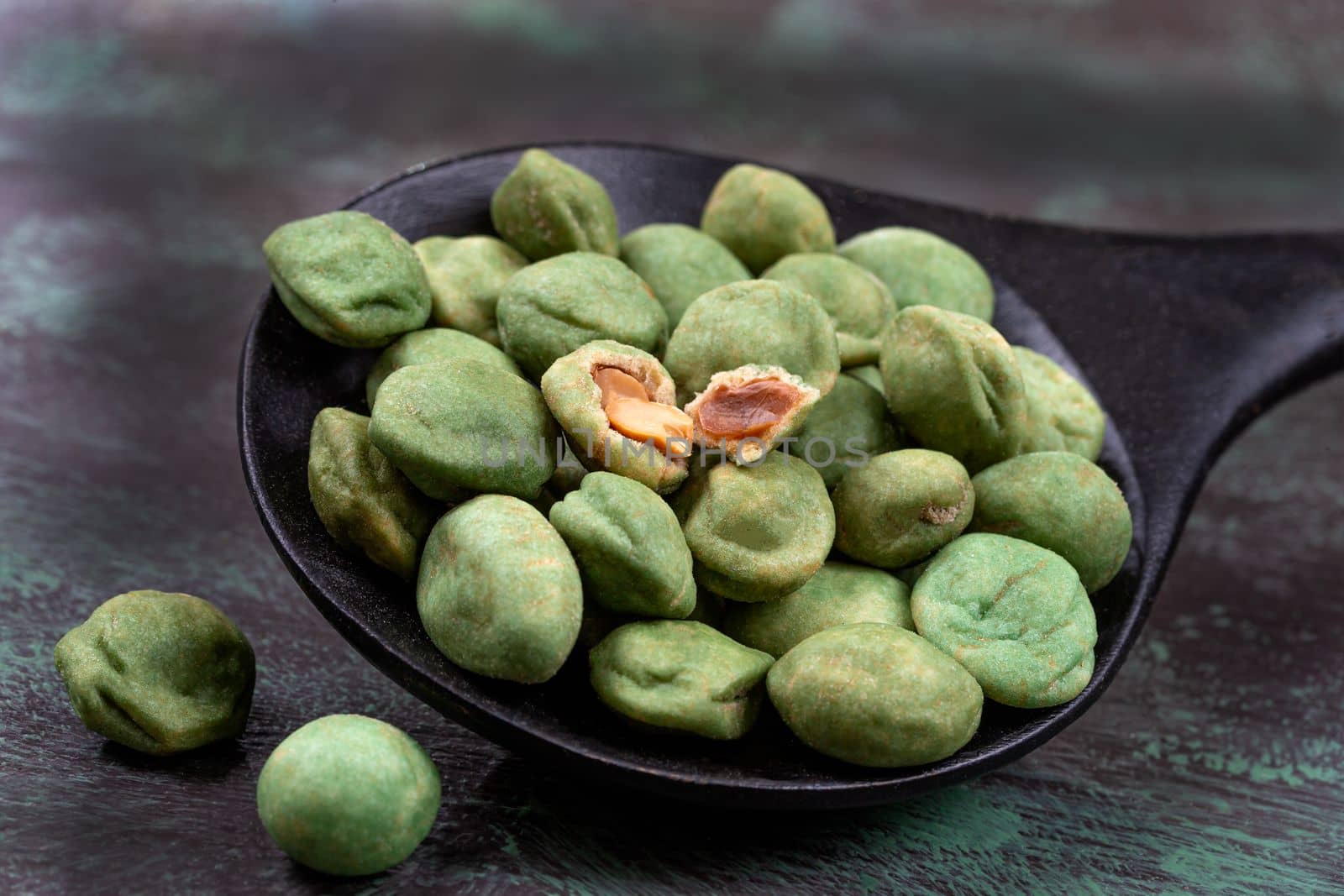 Pile of wasabi coated peanuts isolated on wooden dark grey background by JPC-PROD