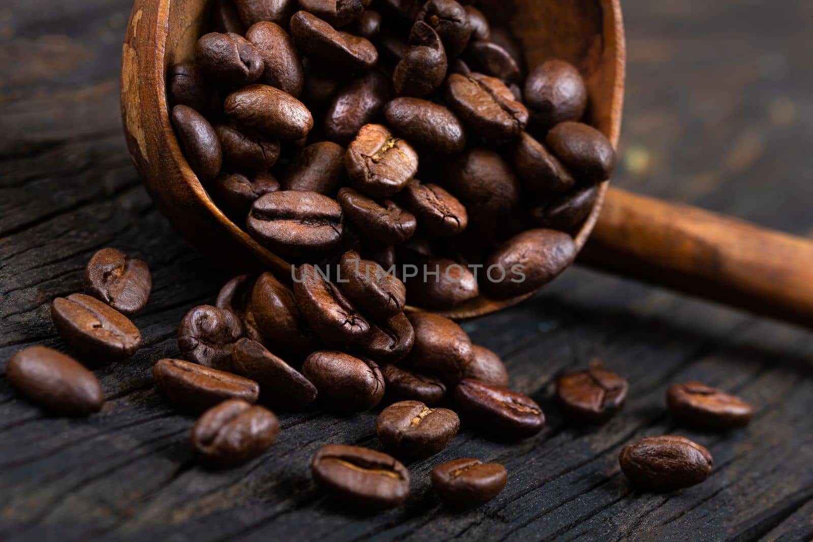 coffee beans with wooden ladle ,on old a wooden background by JPC-PROD