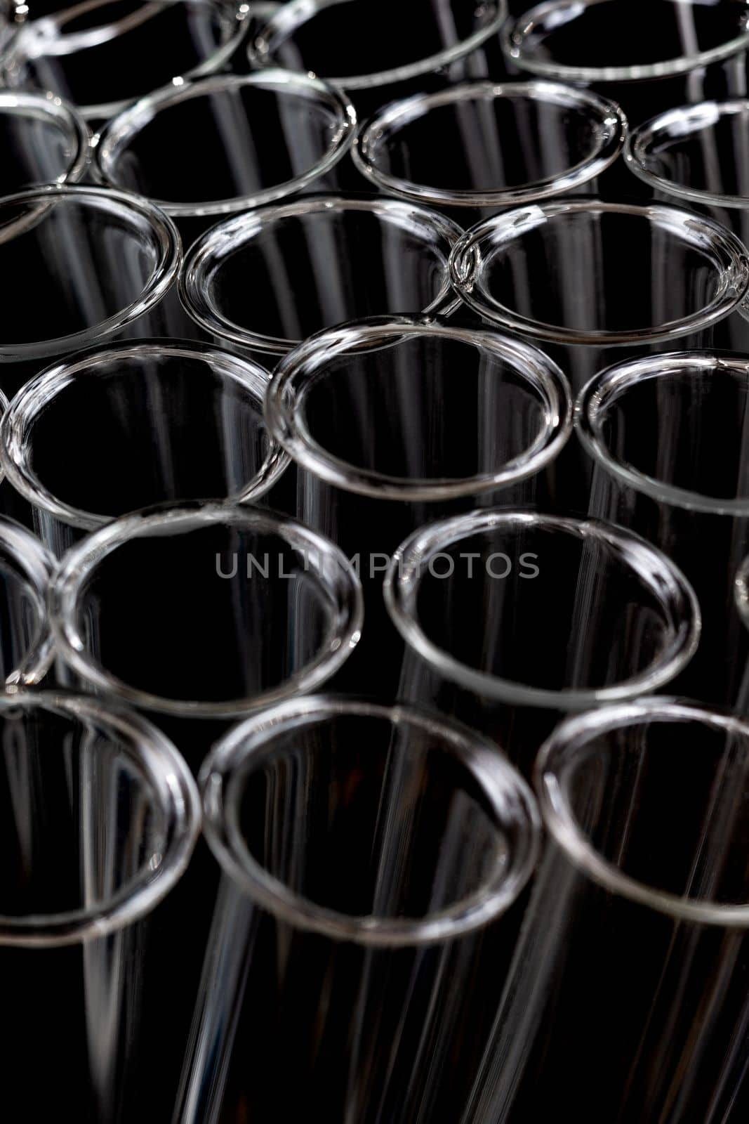 Closeup of empty glass test tubes on a black background in laboratory.. by JPC-PROD
