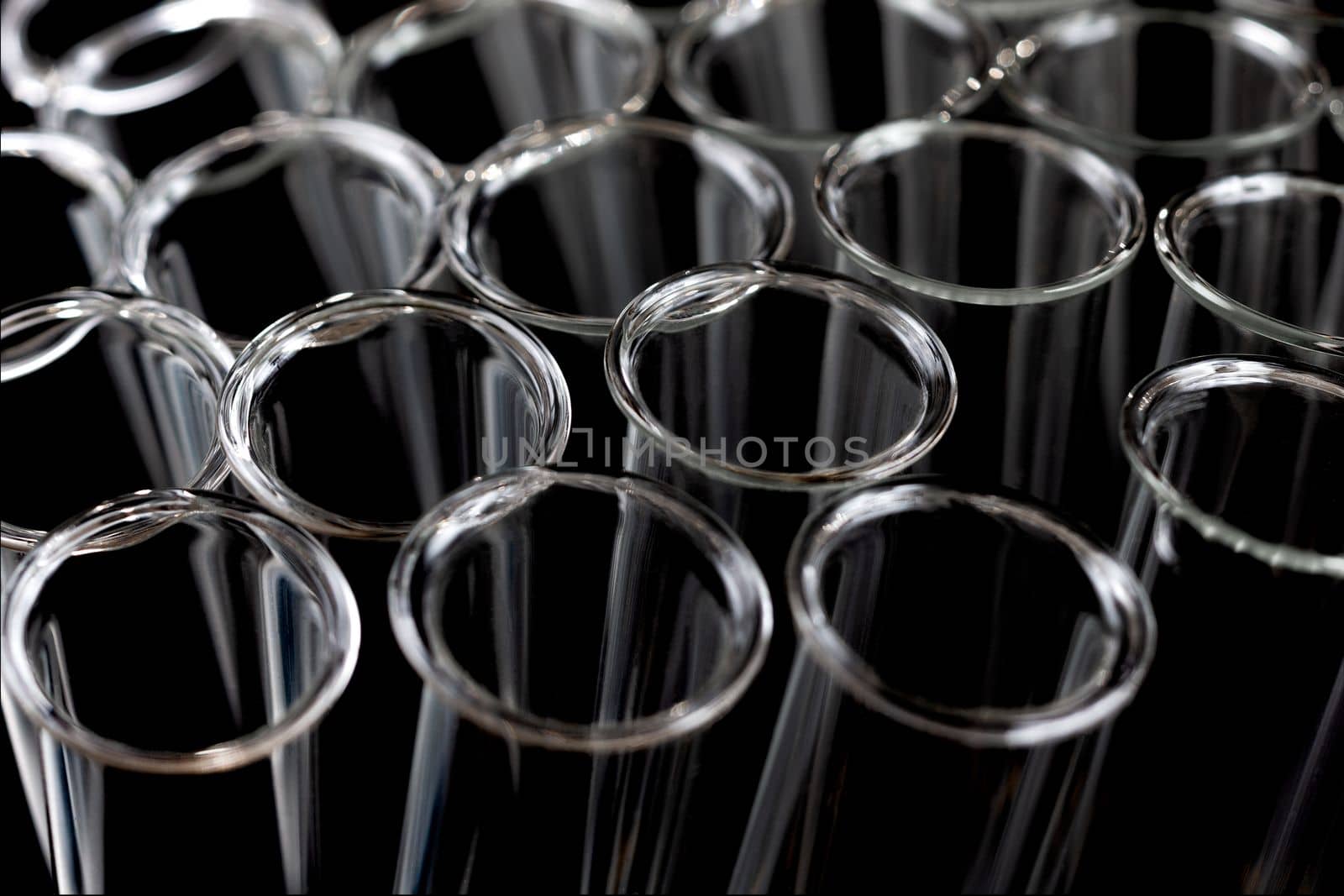 Closeup of empty glass test tubes on a black background in laboratory.. by JPC-PROD