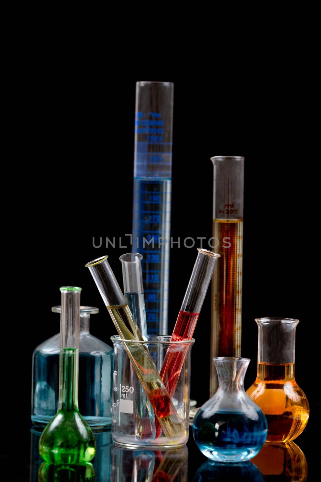 Laboratory equipment and color chemicals on dark background