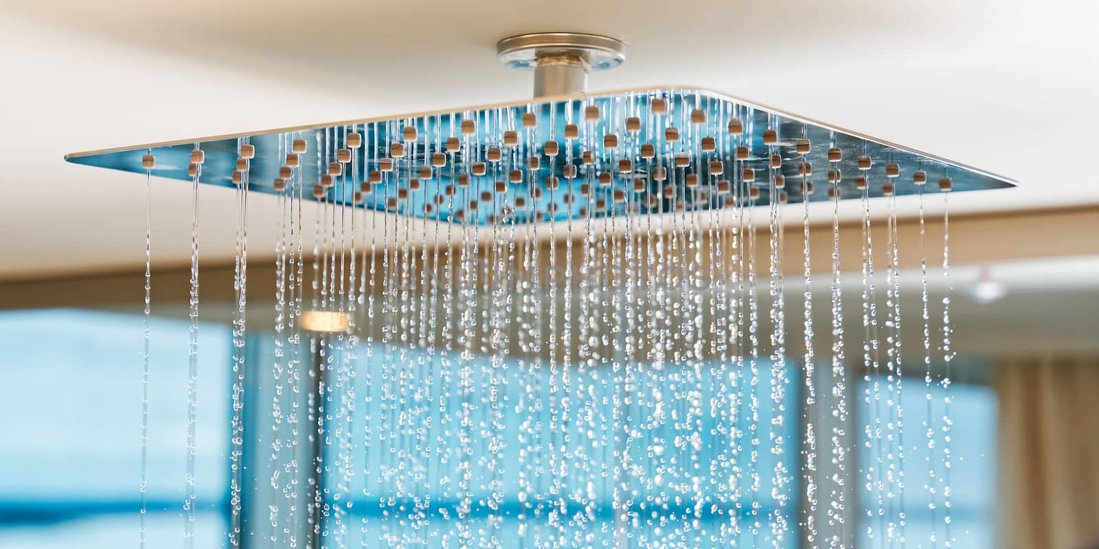 Water flows from the tropical shower. Large water consumption. Chrome shower head, modern design by PhotoTime