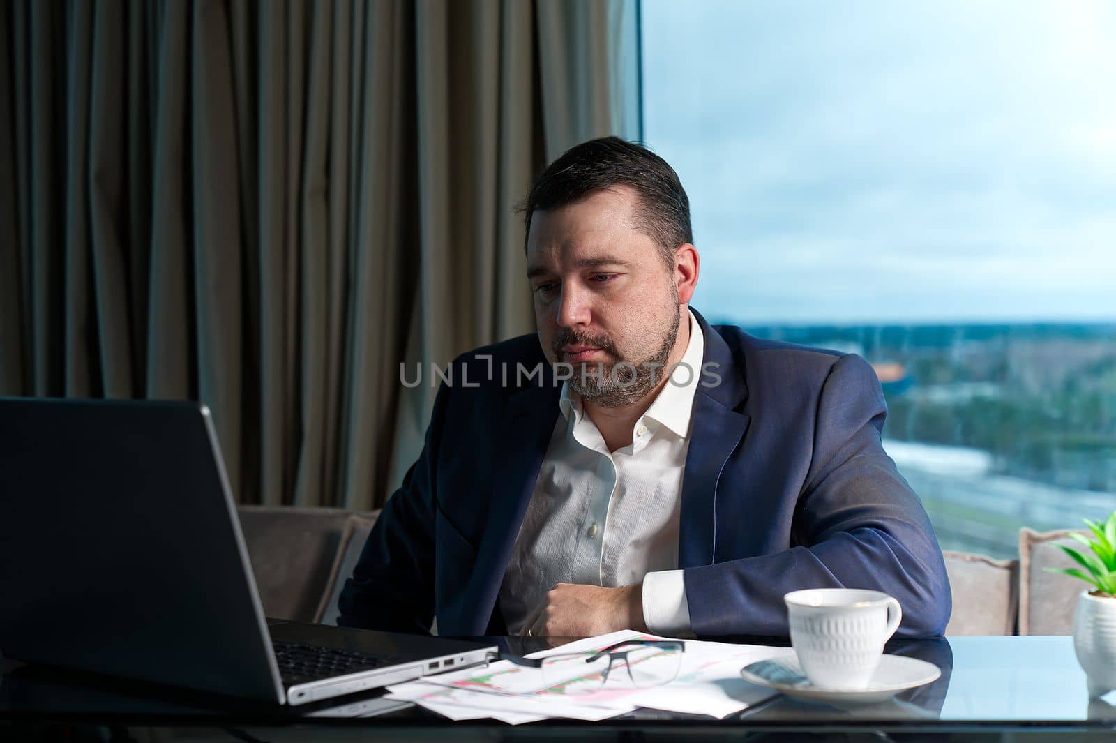 Tired man working at home office, Exhausted, stressed, overworked man, unsuccessful financial investments. by PhotoTime