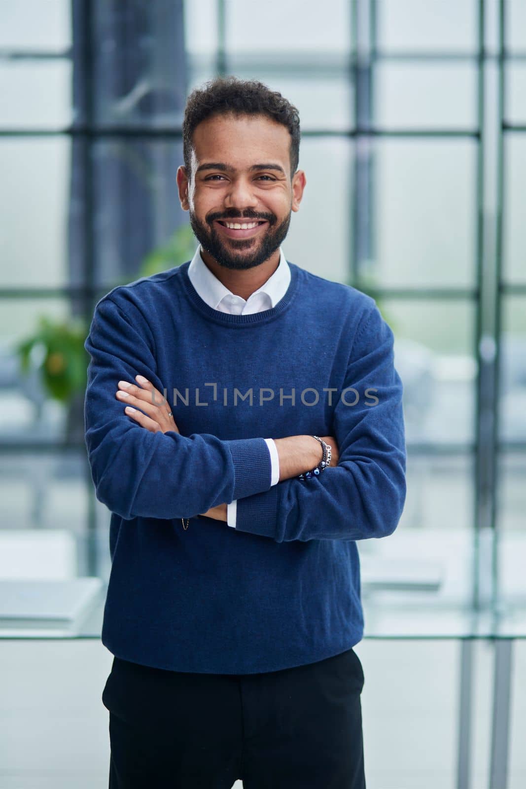 Confidence and charisma. Cheerful young African man keeping arms crossed and looking at camera
