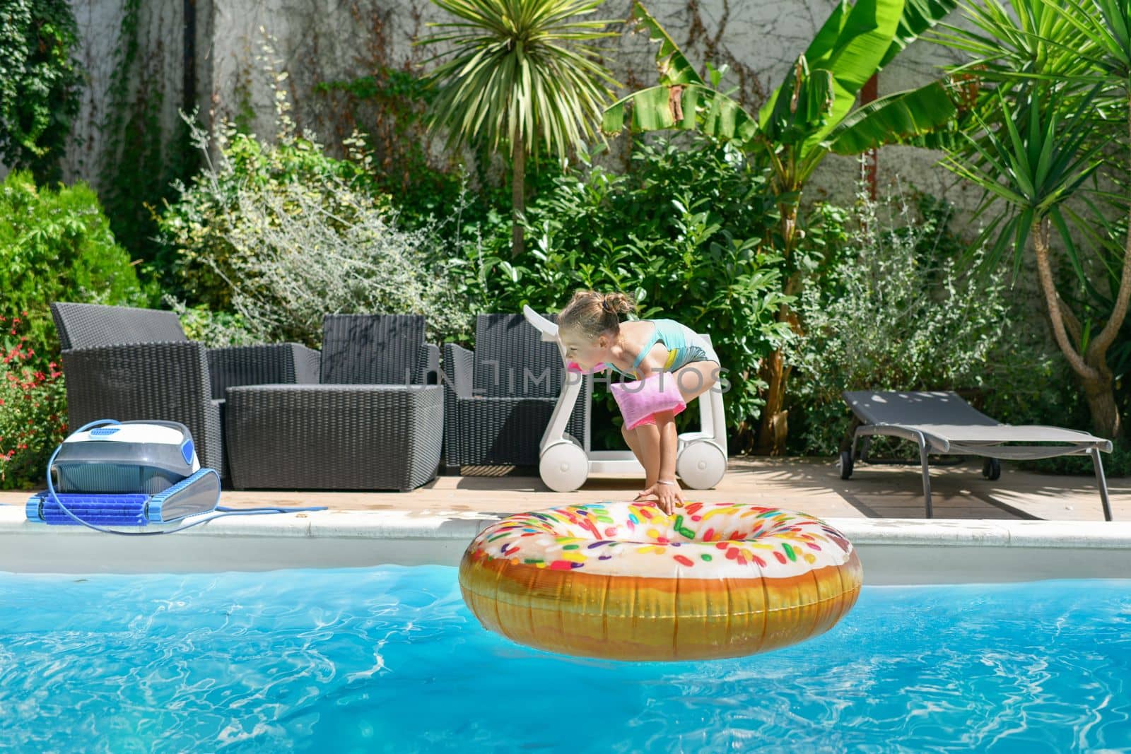 Girl in the pool with an inflatable donut ring