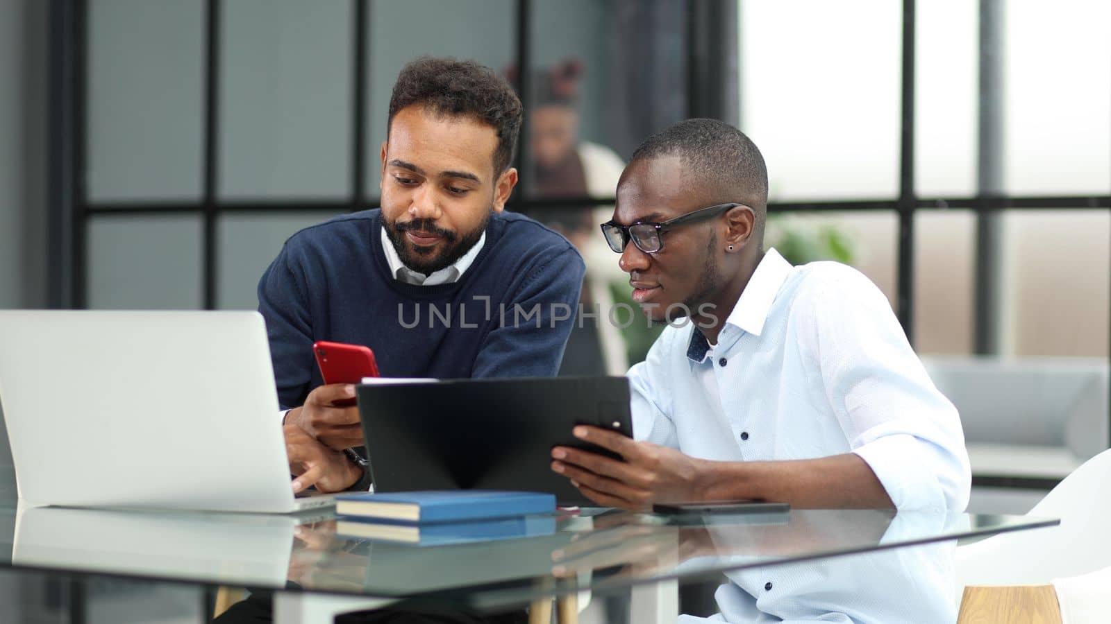 Team of two business people working together in workplace using laptop computer