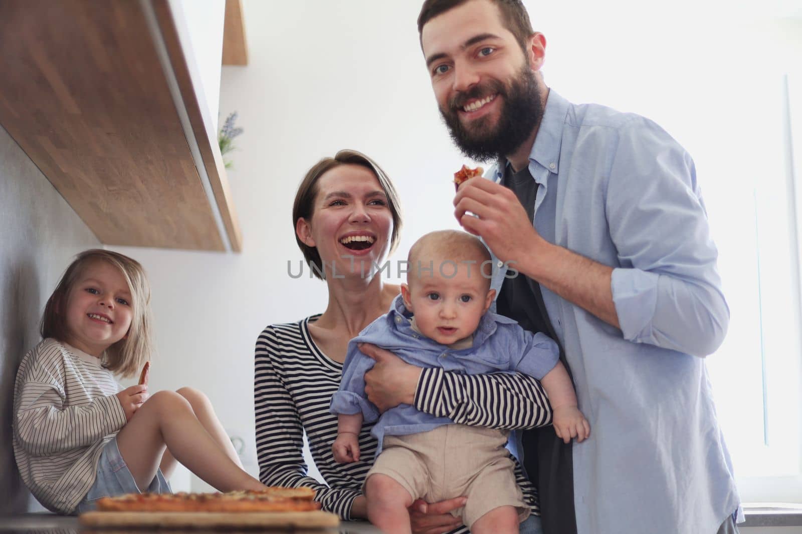 Young family with daughter and son in the kitchen