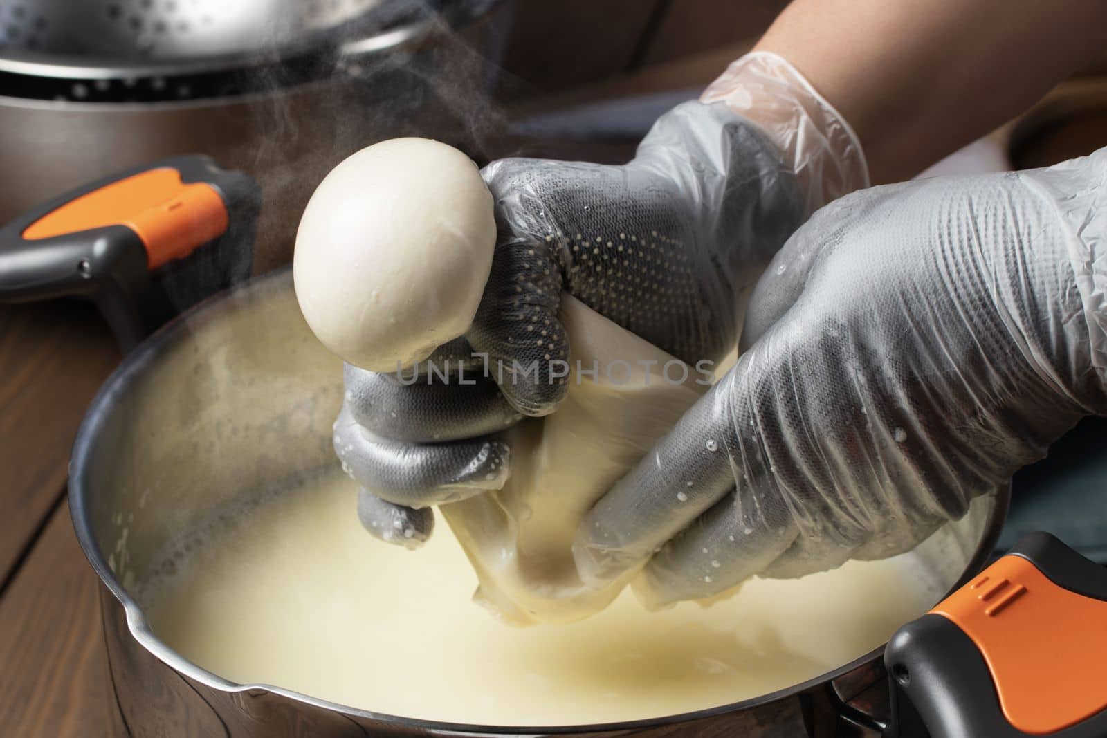 Making mozzarella cheese. Forming balls from cheese curd by galsand