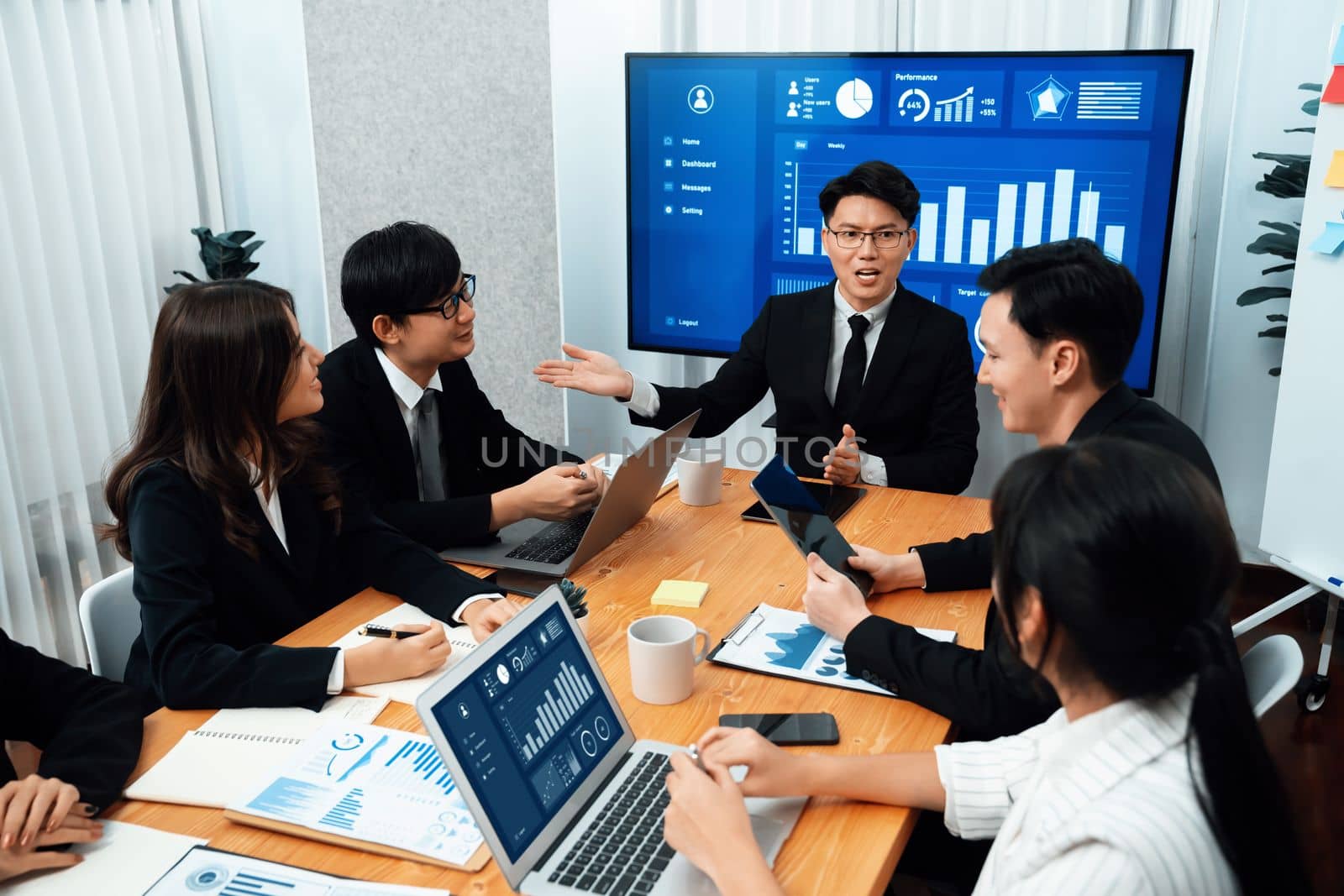 Business team of financial data analysis meeting with business intelligence, report paper and dashboard on laptop for marketing strategy. Business people working together to promote harmony in office.