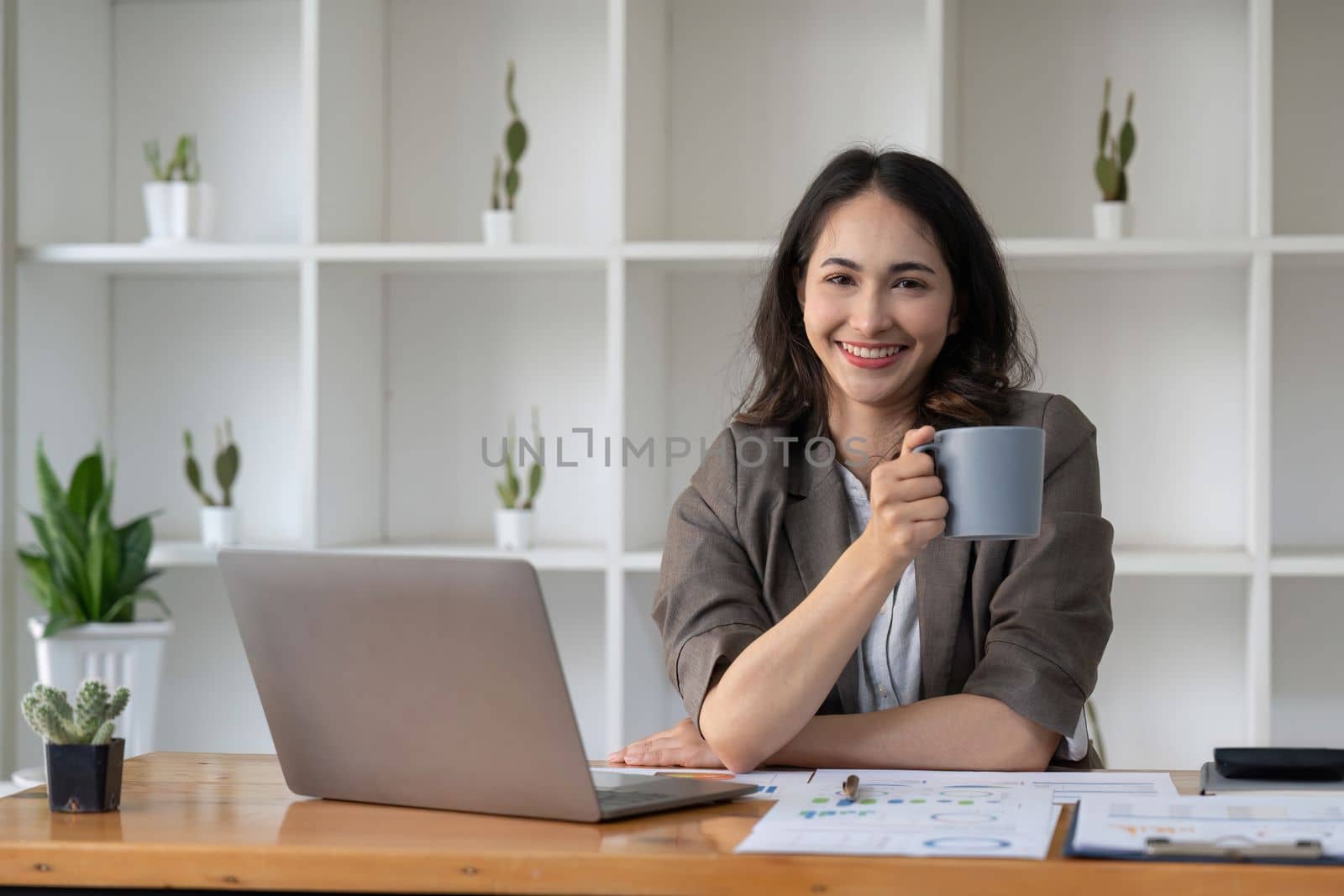 businesswoman sitting in office with digital tablet. Excited asian businesswoman raising hands to congratulate while working on laptop in office by nateemee