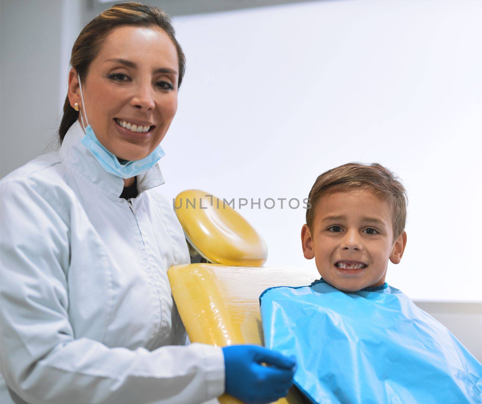 We take care of all our patients no matter how old they are. Portrait of a cheerful young female dentist and her young little patient getting ready for a checkup inside of the office. by YuriArcurs