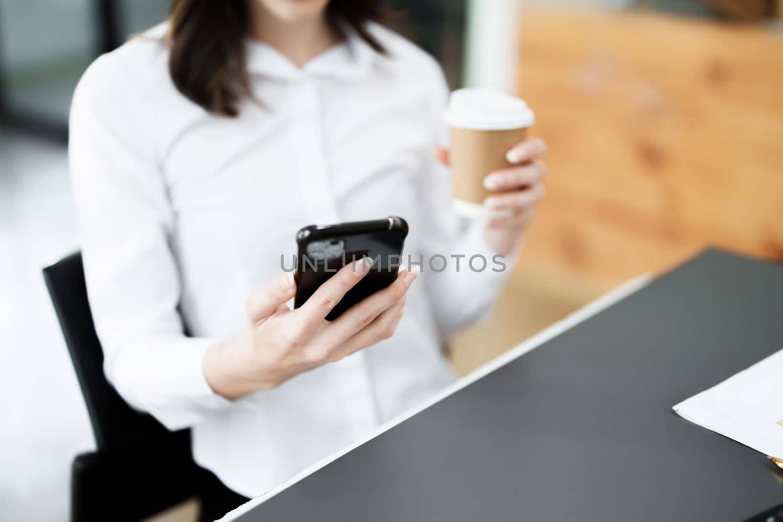 Portrait of a business woman talking on the phone and drinking coffee.