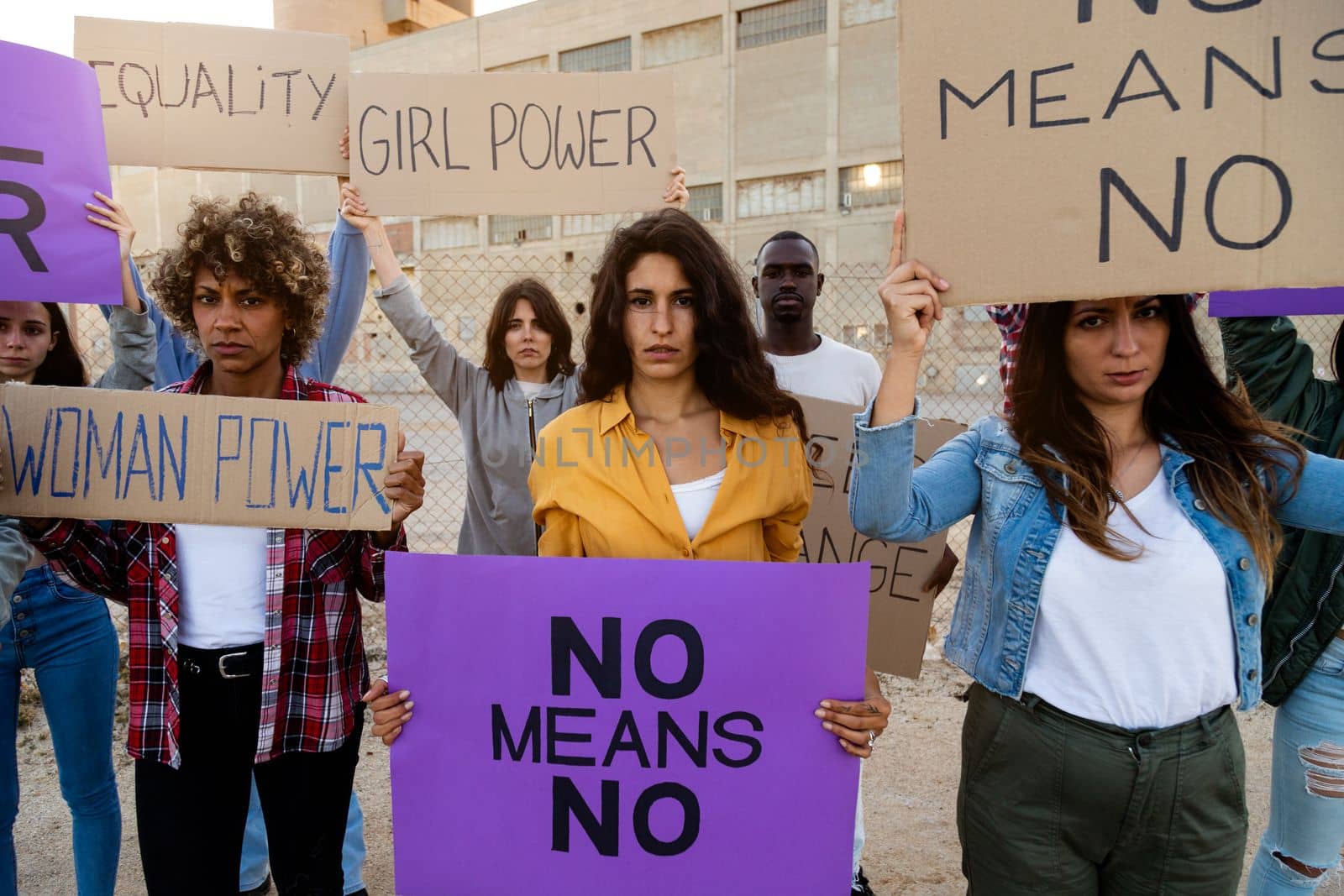 Multiracial group of feminist activist holding protest signs in woman's right march demonstration. Looking at camera. Equality and feminism concept.