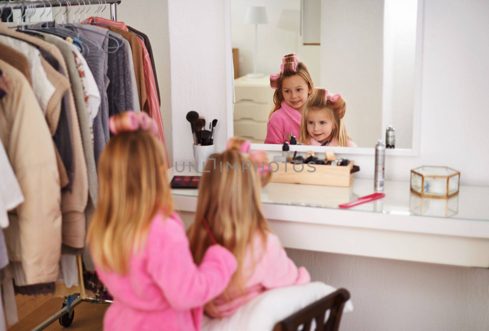 Pretending theyre at the beauty salon. two young sisters playing with moms makeup