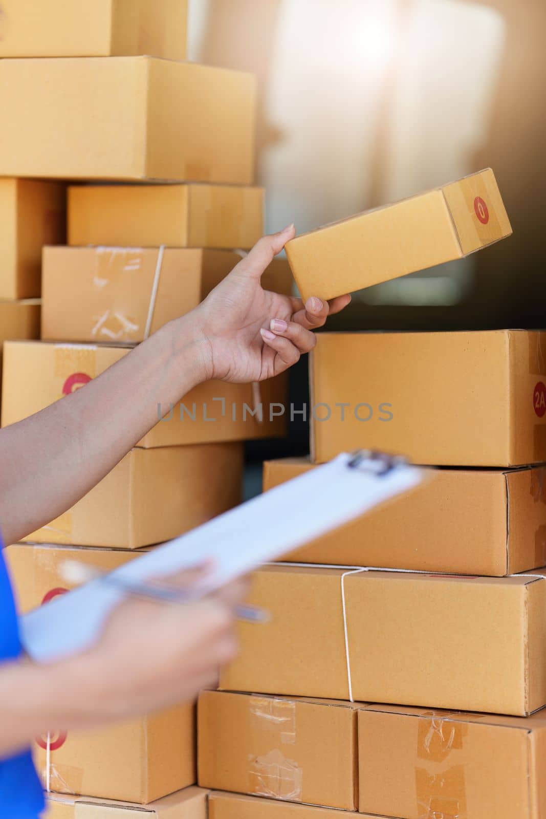 Asian courier with parcel and delivery logistic concept. Delivery man with checking list on clipboard.