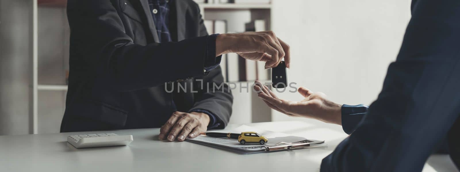 Car rental and Insurance concept, Young salesman giving car is key to customer after sign agreement contract with approved for rent or purchase...