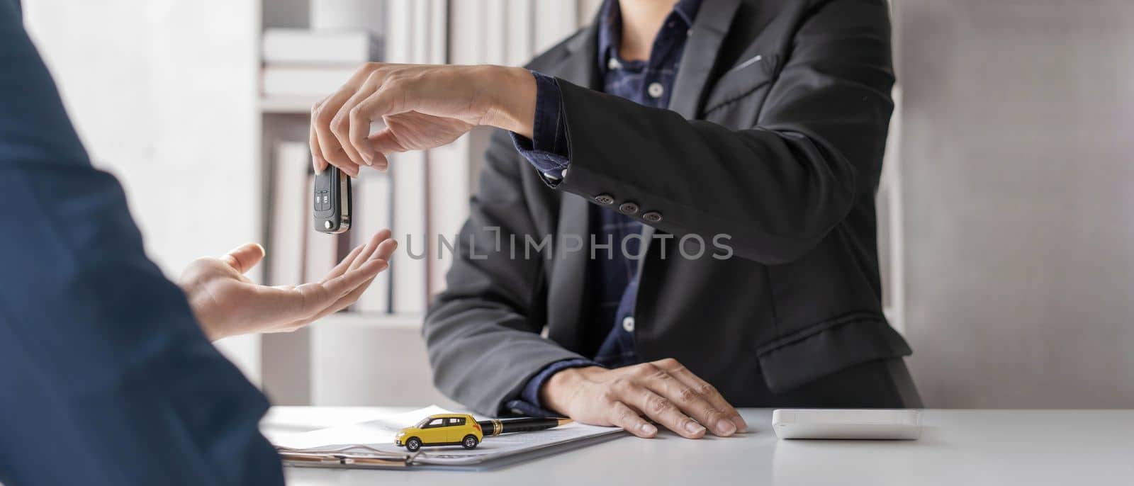 Car rental and Insurance concept, Young salesman giving car is key to customer after sign agreement contract with approved for rent or purchase...