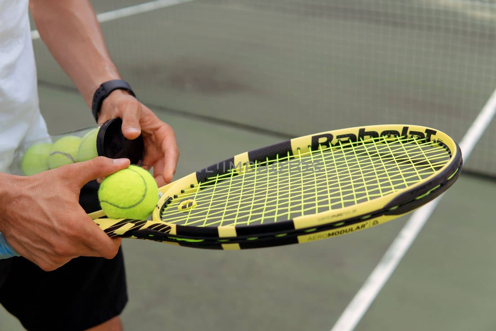 close-up. male hands holding tennis racket and balls by Alexzhilkin