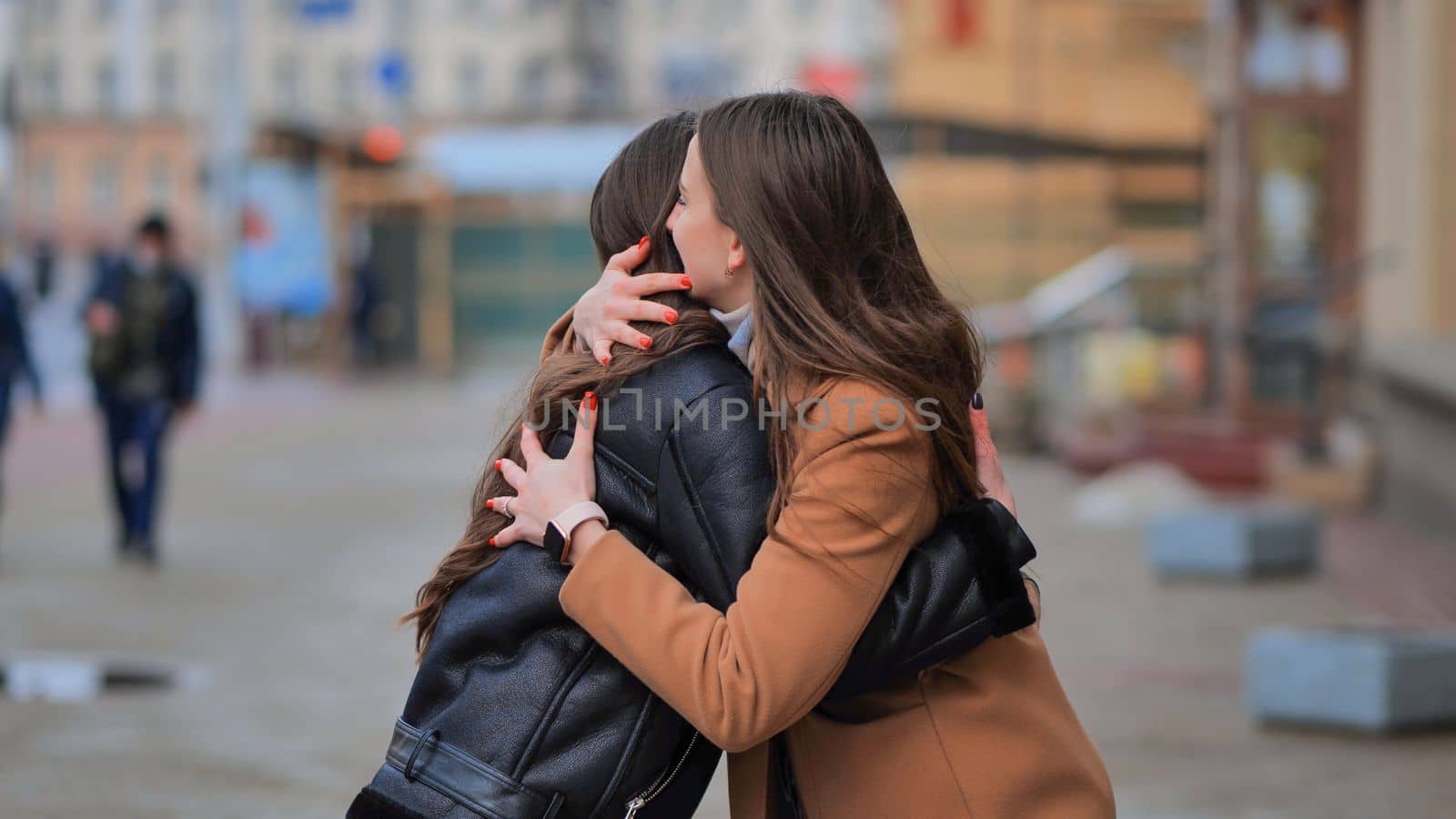 Two friends meet on a city street and are happy together