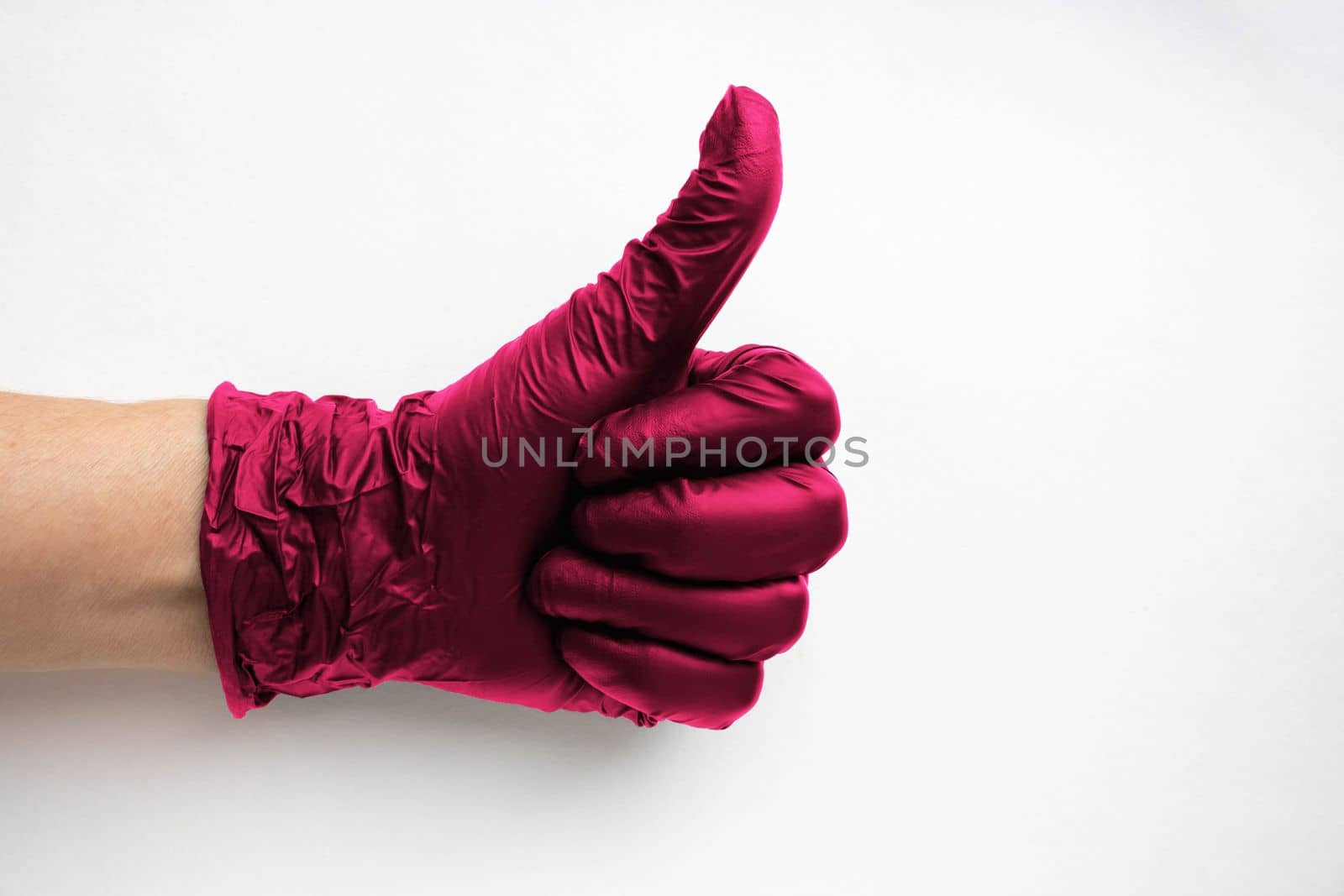 A hand in a surgical medical glove color Viva Magenta, highlighted on a white background. Production of rubber protective gloves.Hygiene and sanitary standards.