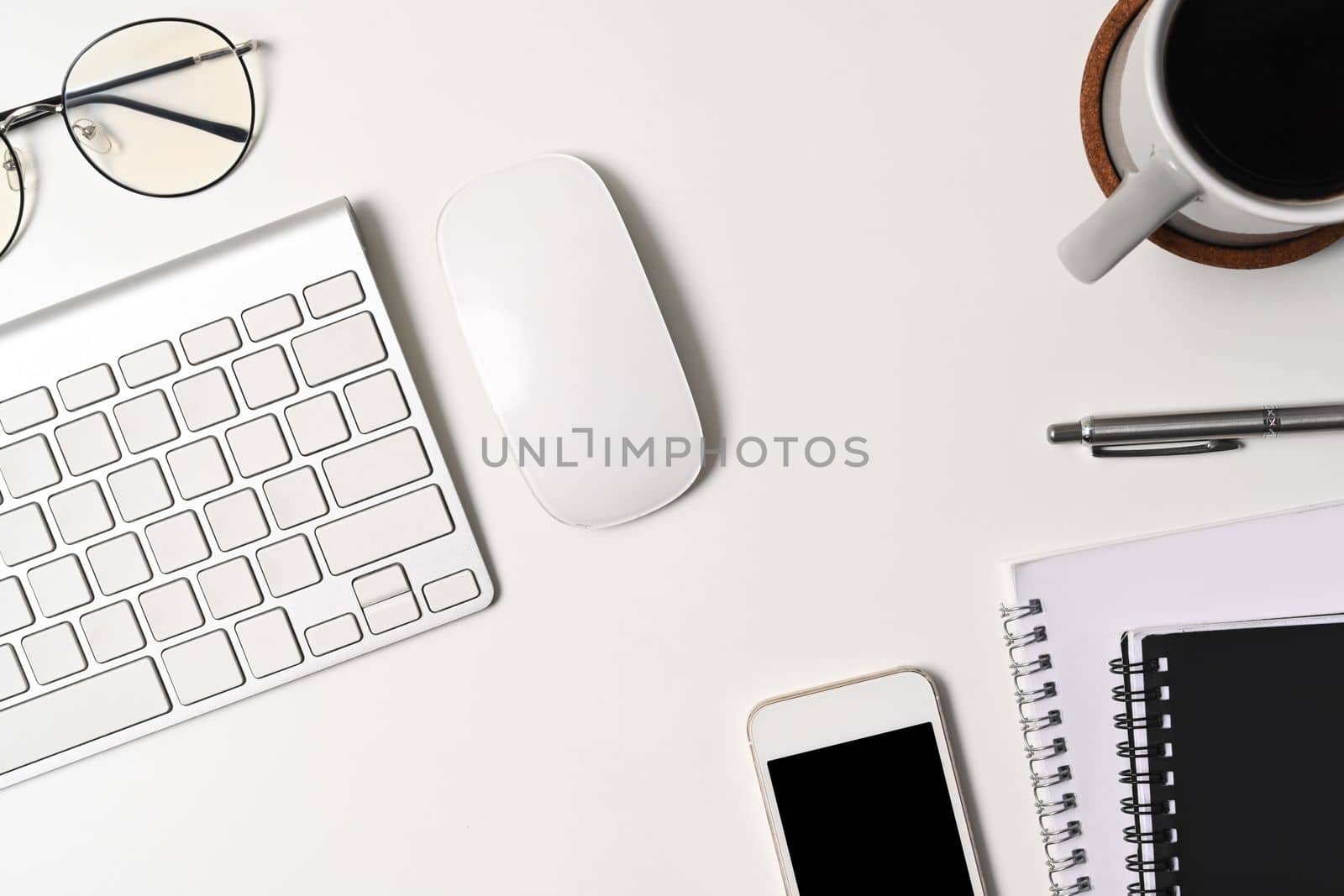 Above view office desk with smart phone, coffee cup and notebook. by prathanchorruangsak