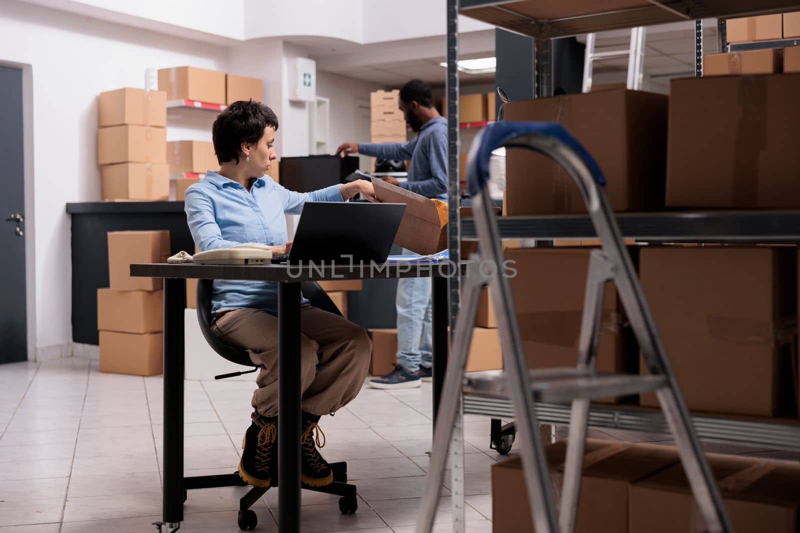 Caucasian worker sitting at desk analyzing customer shipping detalies on laptop computer by DCStudio