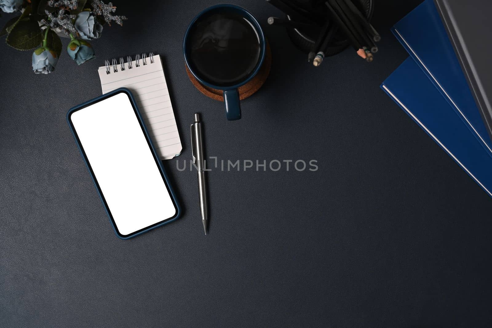 Mock up smart phone, coffee cup and notebook on black leather. by prathanchorruangsak