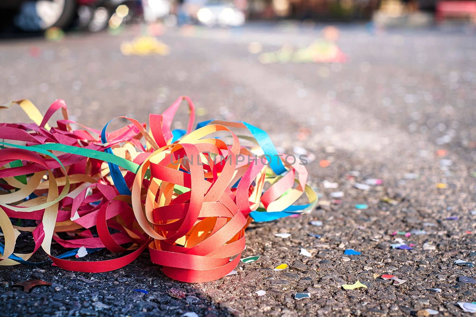 Close up colorful confetti and streamers at the street after Carnival parade