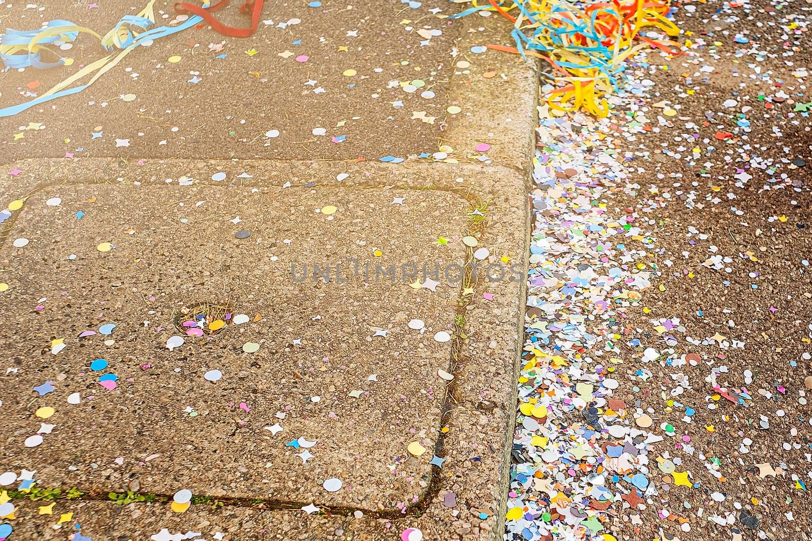 Colorful confetti and streamers at the street after Carnival parade. Italy