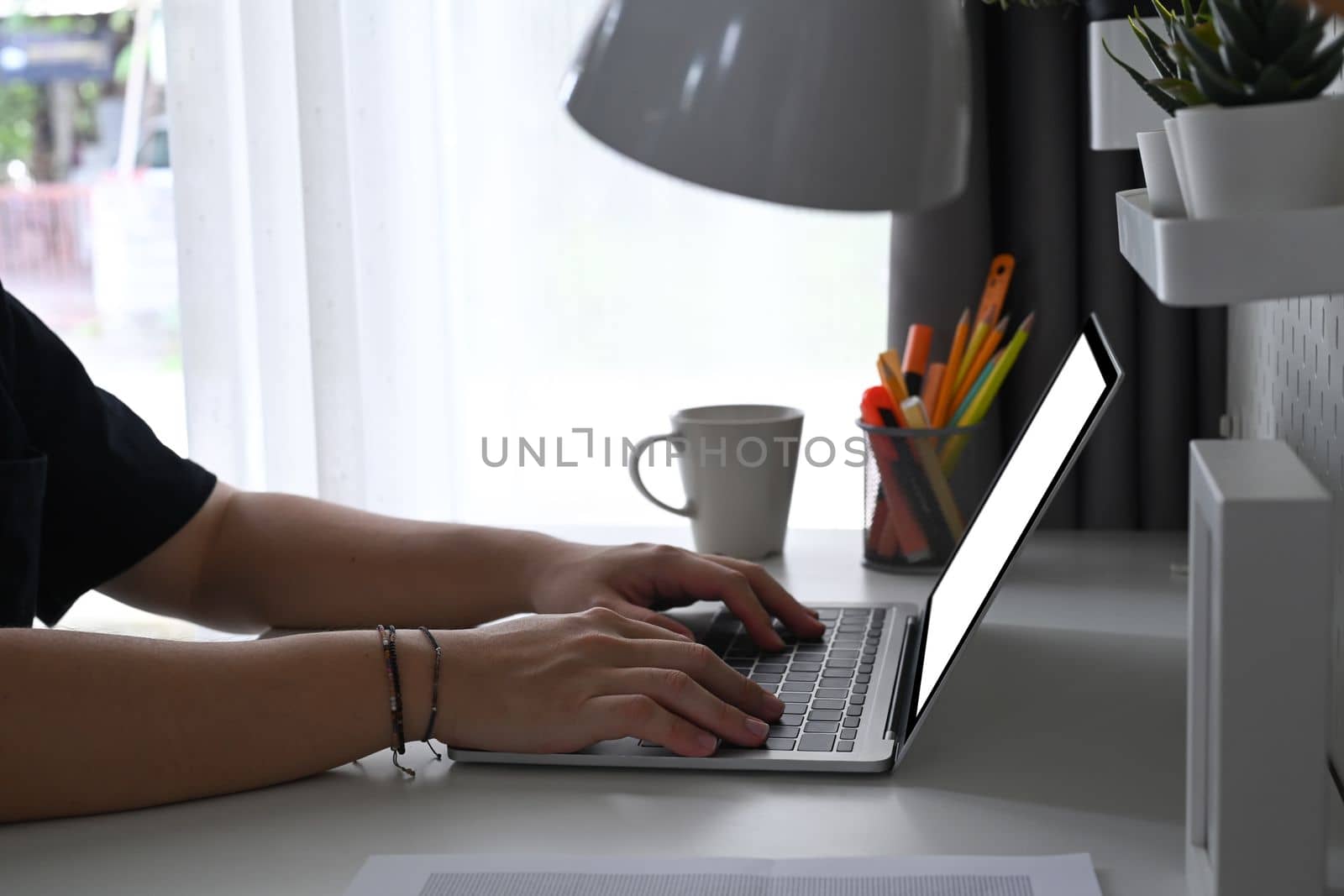 Man working online with computer laptop at home office desk.