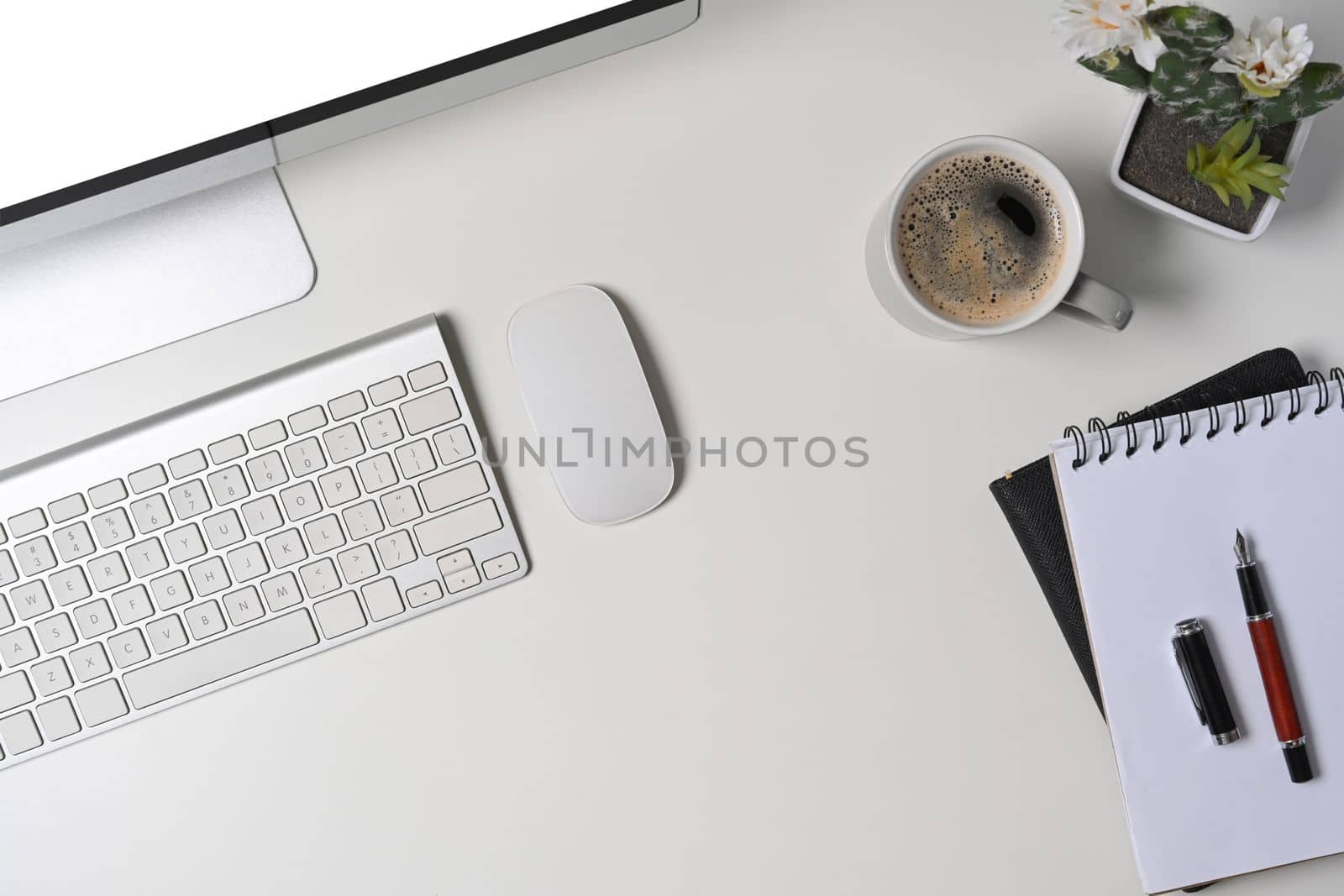 Above view modern workspace with computer, coffee cup and office supplies.