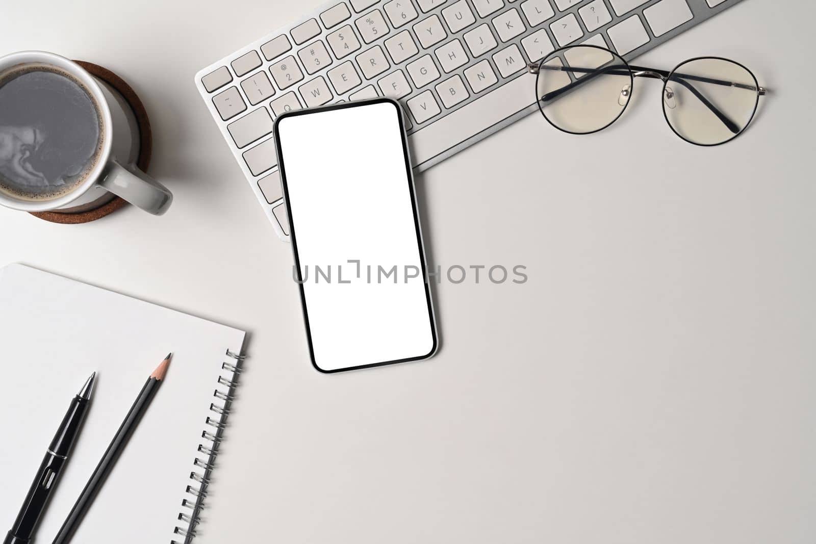 Above view mock up mobile phone with empty screen on white office desk. by prathanchorruangsak