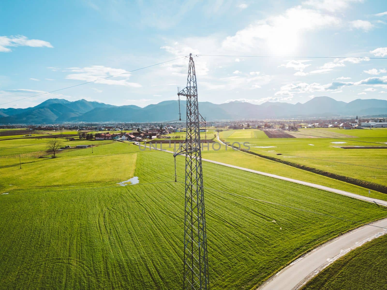 Electrical power substation in the country side of Slovenia. Fields and forests surrounding the power station in the suburbs. Aerial view.