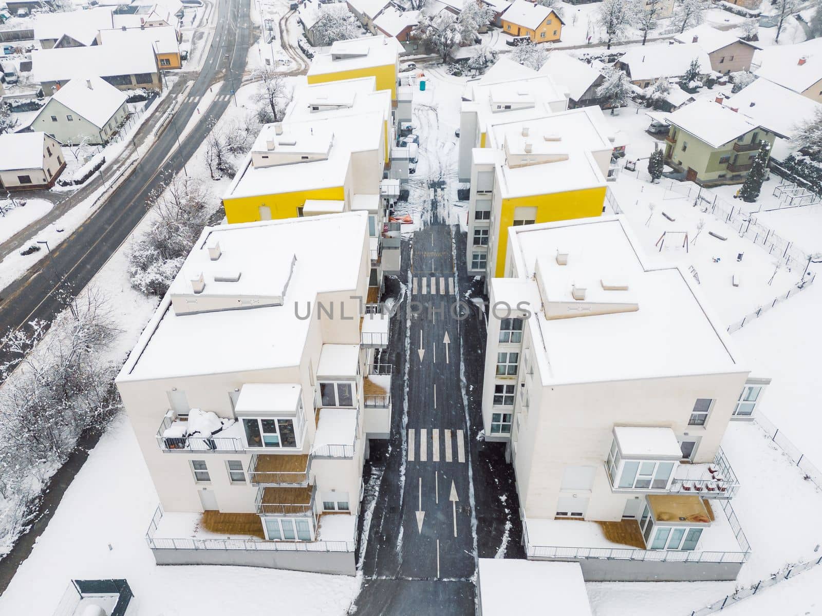 Drone flying over newly build residential buildings with apartments on a snowy winter day by VisualProductions