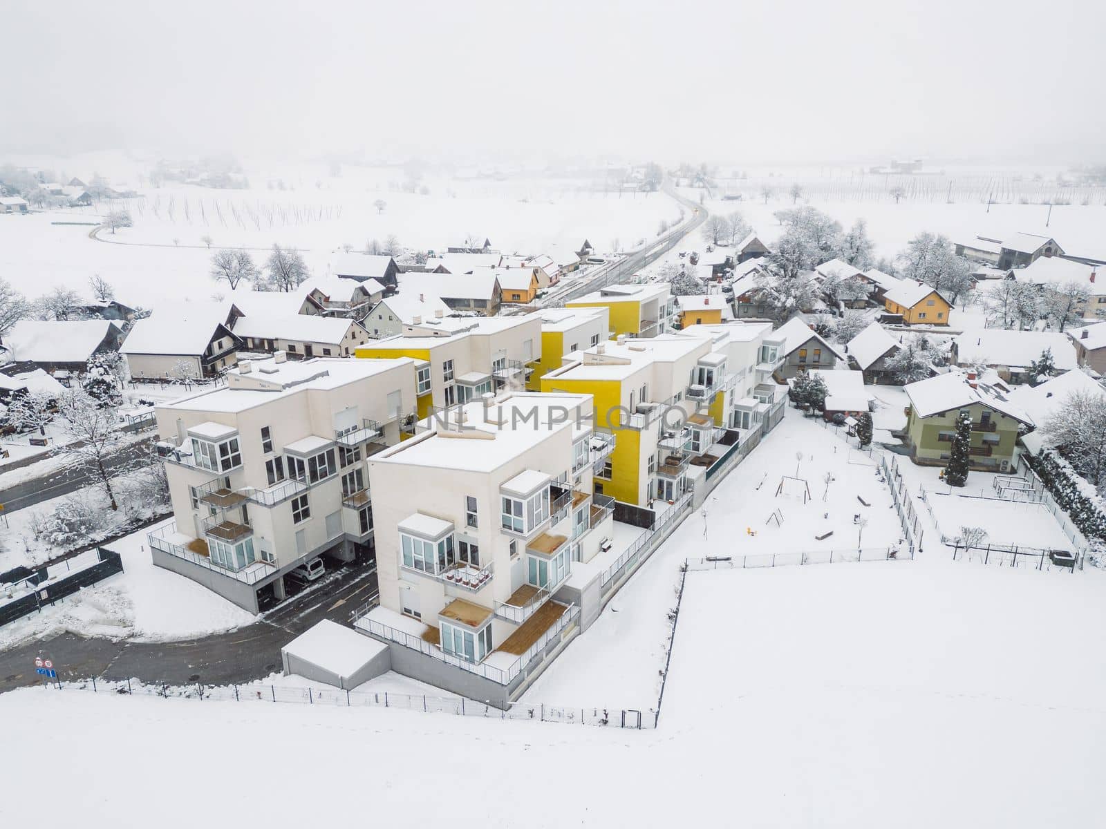 Newly build apartment complex, modern architecture, residential building on a snowy winter day.