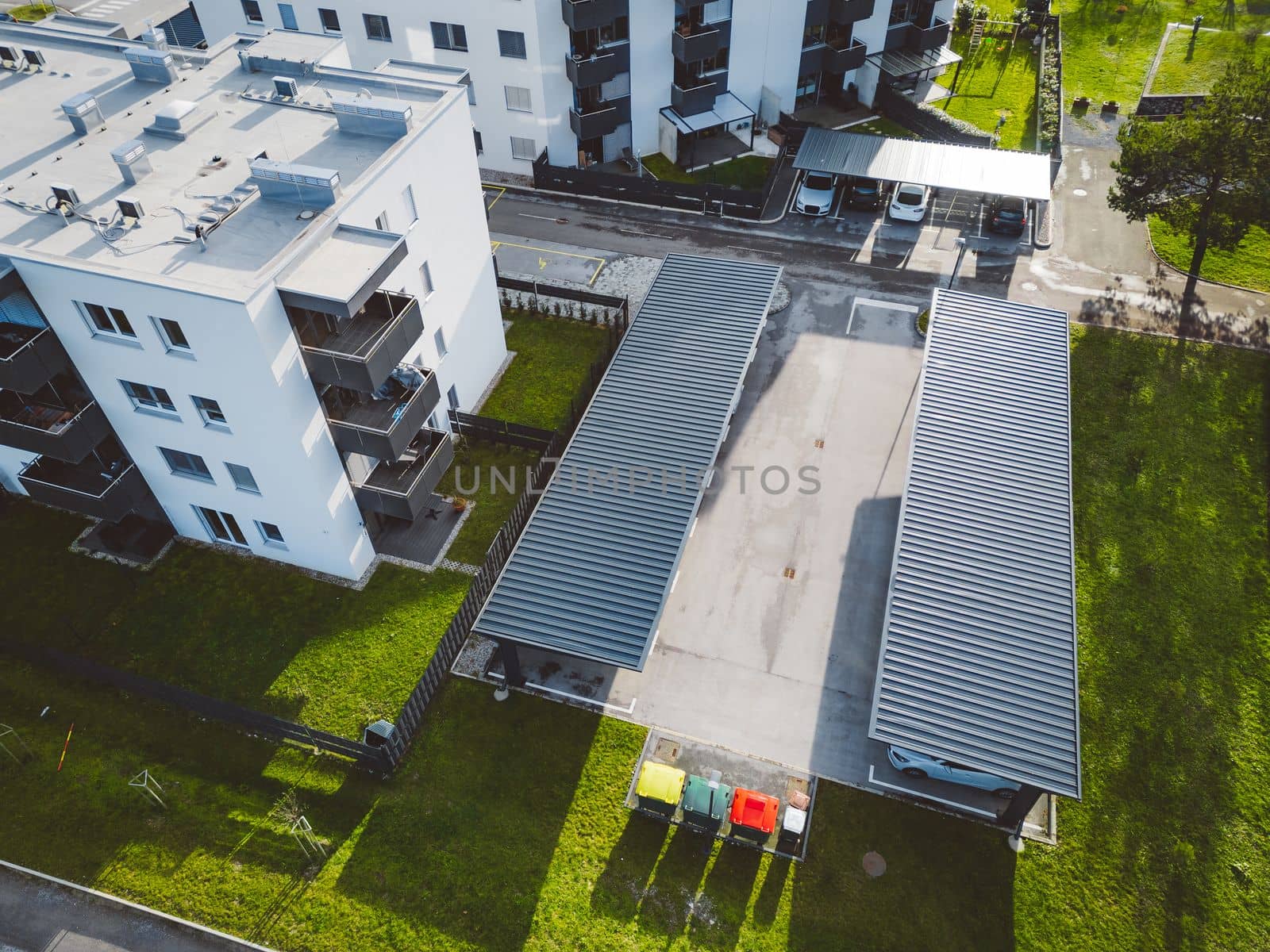 Aerial view of newly build residential buildings with covered parking spaces in front by VisualProductions
